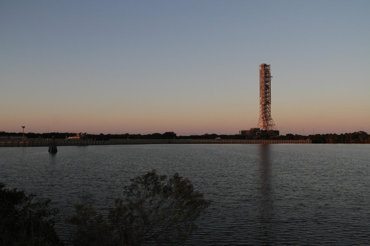 CAPE CANAVERAL, Fla. – The mobile launcher, or ML, makes its way past the turn basin as dusk descends on NASA's Kennedy Space Center in Florida. The ML is nearing the end of its 4.2-mile trek from Launch Pad 39B to the park site near the Vehicle Assembly Building.     Data on the ML collected from structural and functional engineering tests during its two-week stay on the pad will be used in the next phases of construction. The 355-foot-tall ML structure, which took about two years to construct, will be modified by NASA’s 21st Century Ground Systems Program to support NASA’s Space Launch System, the heavy-lift rocket that will launch astronauts into deep space on future exploration missions. For more information, visit http://www.nasa.gov/exploration/systems/sls. Photo credit: NASA/Cory Huston