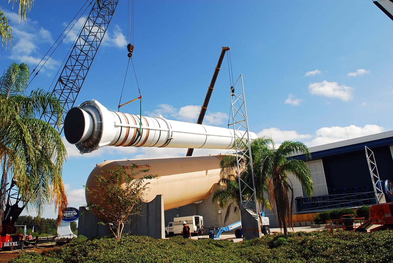 CAPE CANAVERAL, Fla. – Cranes remove a full-size, 149-foot-long, space shuttle solid rocket booster, or SRB, replica from the Kennedy Space Center Visitor Complex as the space-themed attraction makes way for a new exhibit featuring space shuttle Atlantis, which is currently undergoing preparations to go on public display. The SRB is being placed into temporary storage at NASA's Kennedy Space Center. The SRB was part of a mockup of the external tank and two SRBs at the visitor complex that were used to show visitors the size of actual space shuttle components. A space shuttle rode piggyback on the tank and boosters at liftoff and during the ascent into space. The SRBs burned out after about two-and-a-half minutes of flight. After recovery from the ocean, the boosters could be used repeatedly. Photo credit: NASA/Jim Grossman