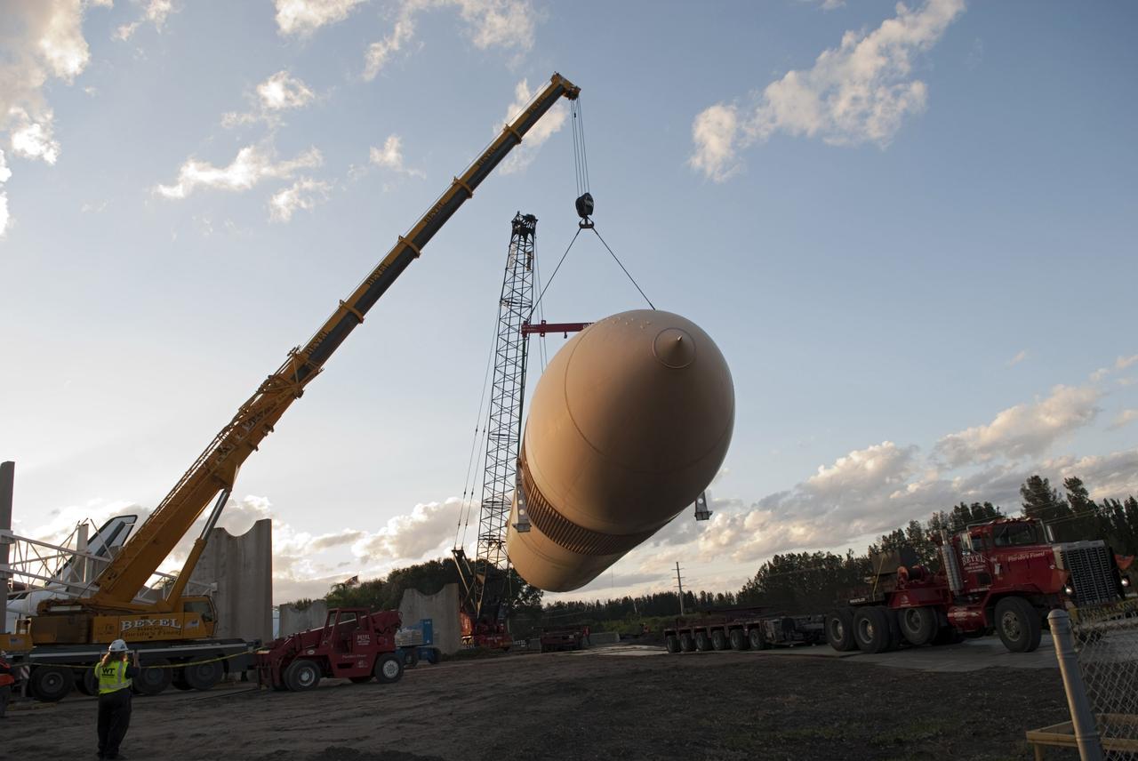 CAPE CANAVERAL, Fla. – Cranes remove a full-size replica of a space shuttle external fuel tank from the Kennedy Space Center Visitor Complex as the space-themed attraction makes way for a new exhibit featuring space shuttle Atlantis, which is currently undergoing preparations to go on public display. The tank is being placed into temporary storage at NASA's Kennedy Space Center. The tank was part of a mockup of the external tank and two solid rocket boosters at the visitor complex that were used to show visitors the size of actual space shuttle components. A space shuttle rode piggyback on the tank and boosters at liftoff and during the ascent into space. The tank, which held propellants for the shuttle's three main engines, was not reused, but burned up in the atmosphere and fell into the ocean. Photo credit: NASA/Jim Grossman
