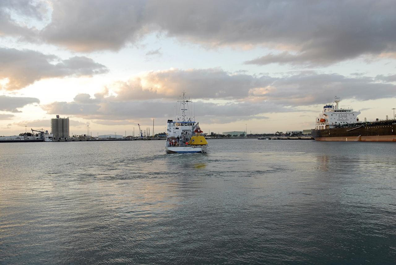 CAPE CANAVERAL, Fla. – At Port Canaveral in Florida, NASA's Liberty Star ship, with an Orion flight test capsule secured to its deck, heads out of port toward the Atlantic Ocean. Liberty Star has been enlisted to support the Crew Module Recovery Attach Fitting Test (CRAFT) which began at-sea operations Nov. 29. Multiple attach clips are being evaluated against the current recovery cleat configuration by U.S. Air Force pararescue jumpers (PJs) and a U.S. Navy diver. The 21st Century Ground Systems Program will use data collected from the tests to help develop ground operations support equipment that could be used to recover an uncrewed Orion flight test capsule after splashdown. The Orion Multi-Purpose Crew Vehicle is NASA's next-generation spacecraft being developed for deep space missions to asteroids, moons and other interplanetary destinations throughout the solar system. For more information, visit http://www.nasa.gov/orion. Photo credit: NASA/Tim Jacobs