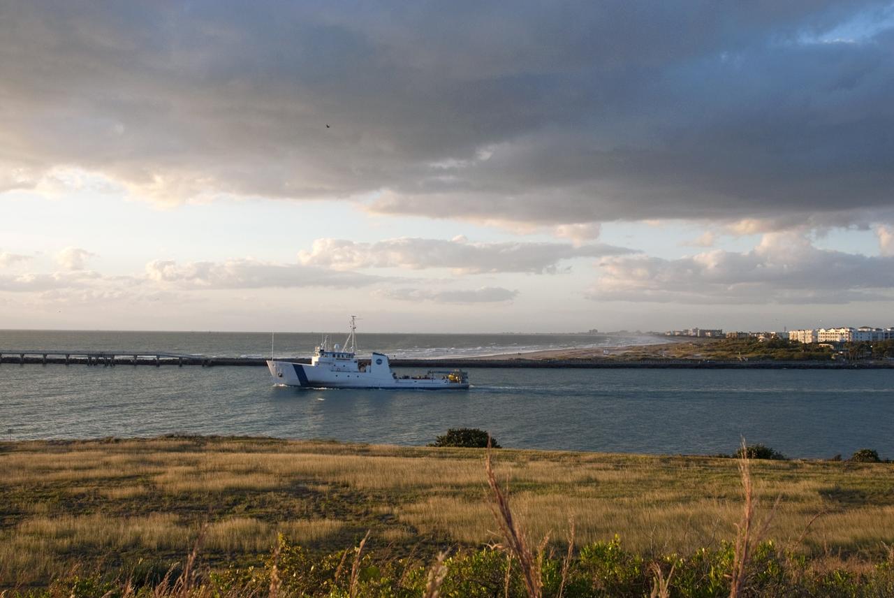 CAPE CANAVERAL, Fla. – NASA's Liberty Star ship, with an Orion flight test capsule secured to its deck, passes through the mouth of Port Canaveral in Florida on its way to the Atlantic Ocean. Liberty Star has been enlisted to support the Crew Module Recovery Attach Fitting Test (CRAFT) which began at-sea operations Nov. 29. Multiple attach clips are being evaluated against the current recovery cleat configuration by U.S. Air Force pararescue jumpers (PJs) and a U.S. Navy diver. The 21st Century Ground Systems Program will use data collected from the tests to help develop ground operations support equipment that could be used to recover an uncrewed Orion flight test capsule after splashdown. The Orion Multi-Purpose Crew Vehicle is NASA's next-generation spacecraft being developed for deep space missions to asteroids, moons and other interplanetary destinations throughout the solar system. For more information, visit http://www.nasa.gov/orion. Photo credit: NASA/Tim Jacobs