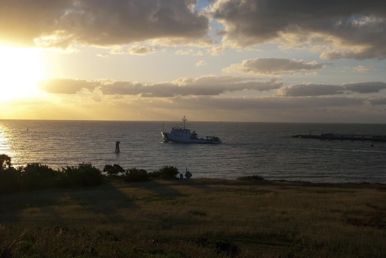 CAPE CANAVERAL, Fla. – NASA's Liberty Star ship, with an Orion flight test capsule secured to its deck, passes through the mouth of Port Canaveral in Florida into the Atlantic Ocean. Liberty Star has been enlisted to support the Crew Module Recovery Attach Fitting Test (CRAFT) which began at-sea operations Nov. 29. Multiple attach clips are being evaluated against the current recovery cleat configuration by U.S. Air Force pararescue jumpers (PJs) and a U.S. Navy diver. The 21st Century Ground Systems Program will use data collected from the tests to help develop ground operations support equipment that could be used to recover an uncrewed Orion flight test capsule after splashdown. The Orion Multi-Purpose Crew Vehicle is NASA's next-generation spacecraft being developed for deep space missions to asteroids, moons and other interplanetary destinations throughout the solar system. For more information, visit http://www.nasa.gov/orion. Photo credit: NASA/Tim Jacobs