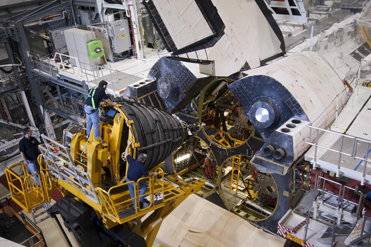 CAPE CANAVERAL, Fla. – Inside Orbiter Processing Facility-1 at NASA's Kennedy Space Center in Florida, an employee guides a replica shuttle main engine (RSME) toward installation on space shuttle Discovery.     This is the first of three replica engines to be installed. The work is part of the Space Shuttle Program’s transition and retirement processing of Discovery. Discovery is being prepared for display at the Smithsonian’s National Air and Space Museum, Steven F. Udvar-Hazy Center in Chantilly, Va. For more information, visit http://www.nasa.gov/shuttle.  Photo credit: NASA/Jim Grossmann