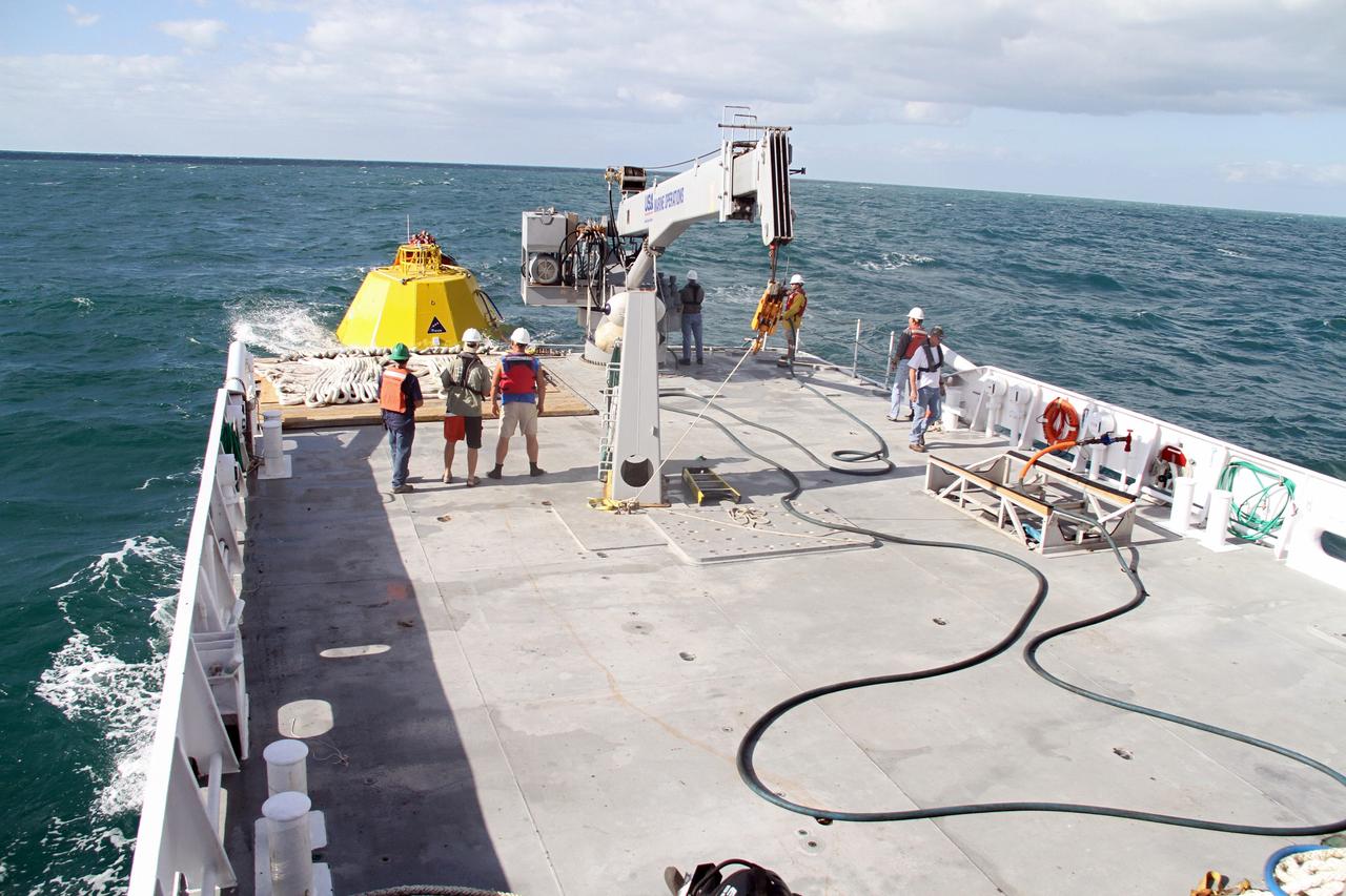 CAPE CANAVERAL, Fla. – Workers on the deck of NASA's Liberty Star ship prepare for testing in the Atlantic Ocean of an Orion flight test capsule to begin.    The Crew Module Recovery Attach Fitting Test (CRAFT) on the capsule, which began at-sea operations Nov. 29, is under way.  Multiple attach clips are being evaluated against the current recovery cleat configuration by U.S. Air Force pararescue jumpers (PJs) and a U.S. Navy diver. The 21st Century Ground Systems Program will use data collected from the tests to help develop ground operations support equipment that could be used to recover an uncrewed Orion flight test capsule after splashdown. The Orion Multi-Purpose Crew Vehicle is NASA's next-generation spacecraft being developed for deep space missions to asteroids, moons and other interplanetary destinations throughout the solar system. For more information, visit http://www.nasa.gov/orion. Photo credit: NASA/Cory Huston