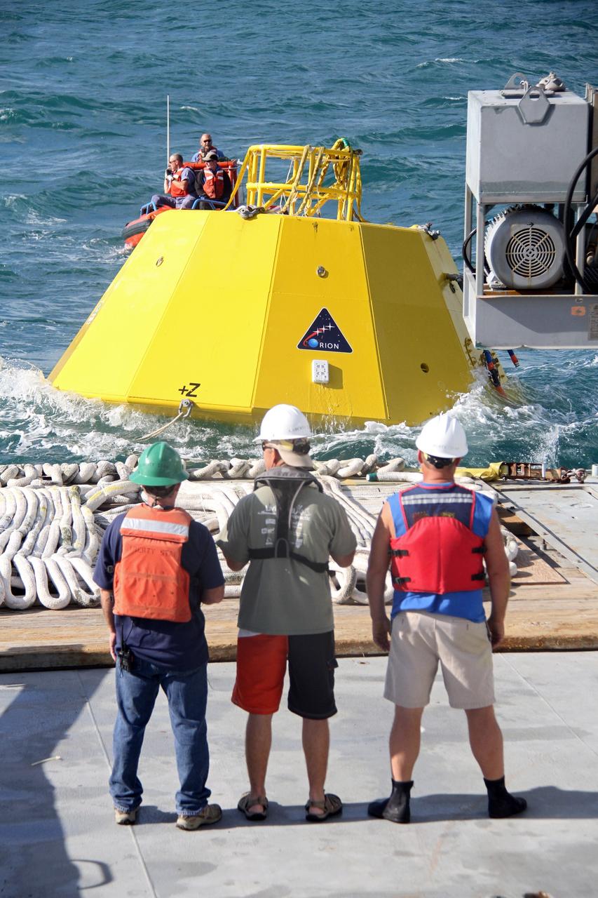 CAPE CANAVERAL, Fla. – Workers, on the deck of NASA's Liberty Star ship and in a boat in the Atlantic Ocean, prepare to begin testing of an Orion flight test capsule.    The Crew Module Recovery Attach Fitting Test (CRAFT) on the capsule, which began at-sea operations Nov. 29, is under way.  Multiple attach clips are being evaluated against the current recovery cleat configuration by U.S. Air Force pararescue jumpers (PJs) and a U.S. Navy diver. The 21st Century Ground Systems Program will use data collected from the tests to help develop ground operations support equipment that could be used to recover an uncrewed Orion flight test capsule after splashdown. The Orion Multi-Purpose Crew Vehicle is NASA's next-generation spacecraft being developed for deep space missions to asteroids, moons and other interplanetary destinations throughout the solar system. For more information, visit http://www.nasa.gov/orion. Photo credit: NASA/Cory Huston