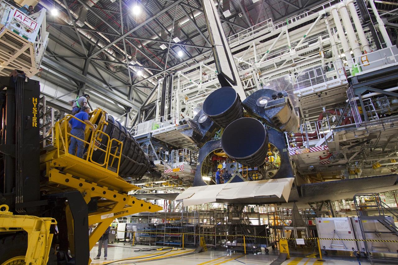 CAPE CANAVERAL, Fla. – Workers in Orbiter Processing Facility-1 at NASA’s Kennedy Space Center in Florida move a replica shuttle main engine (RSME) toward space shuttle Discovery with the aid of a Hyster forklift, a specially designed engine installer.    The RSME is one of three being installed on Discovery during Space Shuttle Program transition and retirement activities. The replicas are built in the Pratt & Whitney Rocketdyne engine shop at Kennedy to replace the shuttle engines which will be placed in storage to support NASA's Space Launch System, under development. Discovery is being prepared for display at the Smithsonian’s National Air and Space Museum Steven F. Udvar-Hazy Center in Chantilly, Va. For more information, visit http://www.nasa.gov/shuttle.  Photo credit: NASA/Jim Grossmann