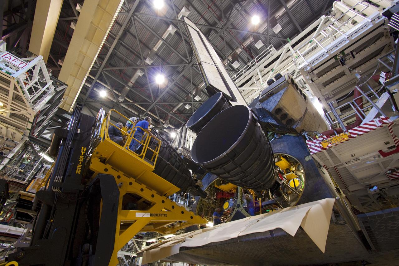 CAPE CANAVERAL, Fla. – In Orbiter Processing Facility-1 at NASA’s Kennedy Space Center in Florida, workers position a replica shuttle main engine (RSME) into the engine well of space shuttle Discovery with the aid of a Hyster forklift, a specially designed engine installer.    The RSME is one of three being installed on Discovery during Space Shuttle Program transition and retirement activities. The replicas are built in the Pratt & Whitney Rocketdyne engine shop at Kennedy to replace the shuttle engines which will be placed in storage to support NASA's Space Launch System, under development. Discovery is being prepared for display at the Smithsonian’s National Air and Space Museum Steven F. Udvar-Hazy Center in Chantilly, Va. For more information, visit http://www.nasa.gov/shuttle.  Photo credit: NASA/Jim Grossmann