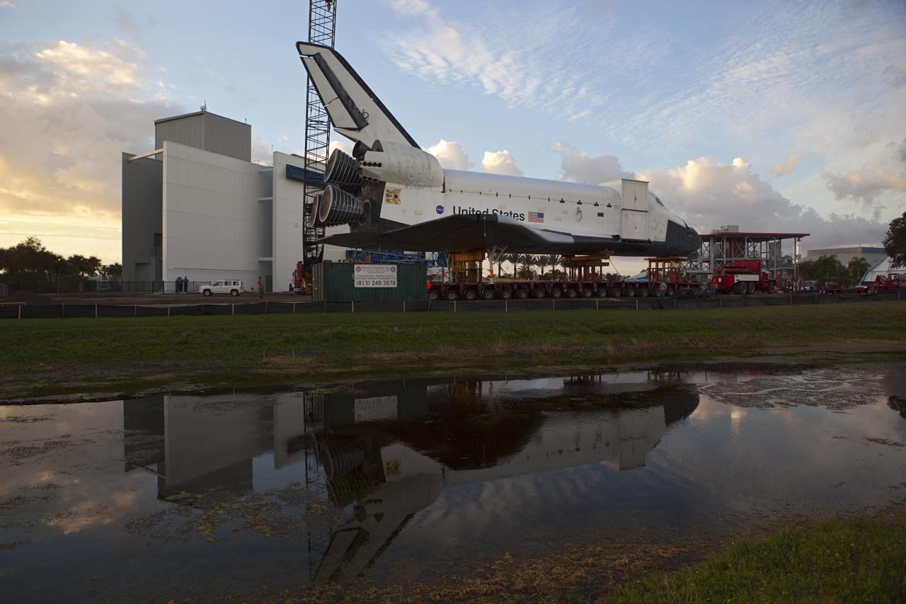 CAPE CANAVERAL, Fla. – Preparations to transport the high-fidelity space shuttle model to NASA Kennedy Space Center's Launch Complex 39 turn basin is reflected in the water near the Kennedy Space Center Visitor Complex in Florida.  The shuttle was part of a display at the visitor complex that also included an external tank and two solid rocket boosters that were used to show visitors the size of actual space shuttle components. The full-scale shuttle model is being transferred from Kennedy to Space Center Houston, NASA Johnson Space Center's visitor center. The model will stay at the turn basin for a few months until it is ready to be transported to Texas via barge. The move also helps clear the way for the Kennedy Space Center Visitor Complex to begin construction of a new facility next year to display space shuttle Atlantis in 2013.  For more information about Space Center Houston, visit http://www.spacecenter.org.  Photo credit: NASA/Dimitri Gerondidakis