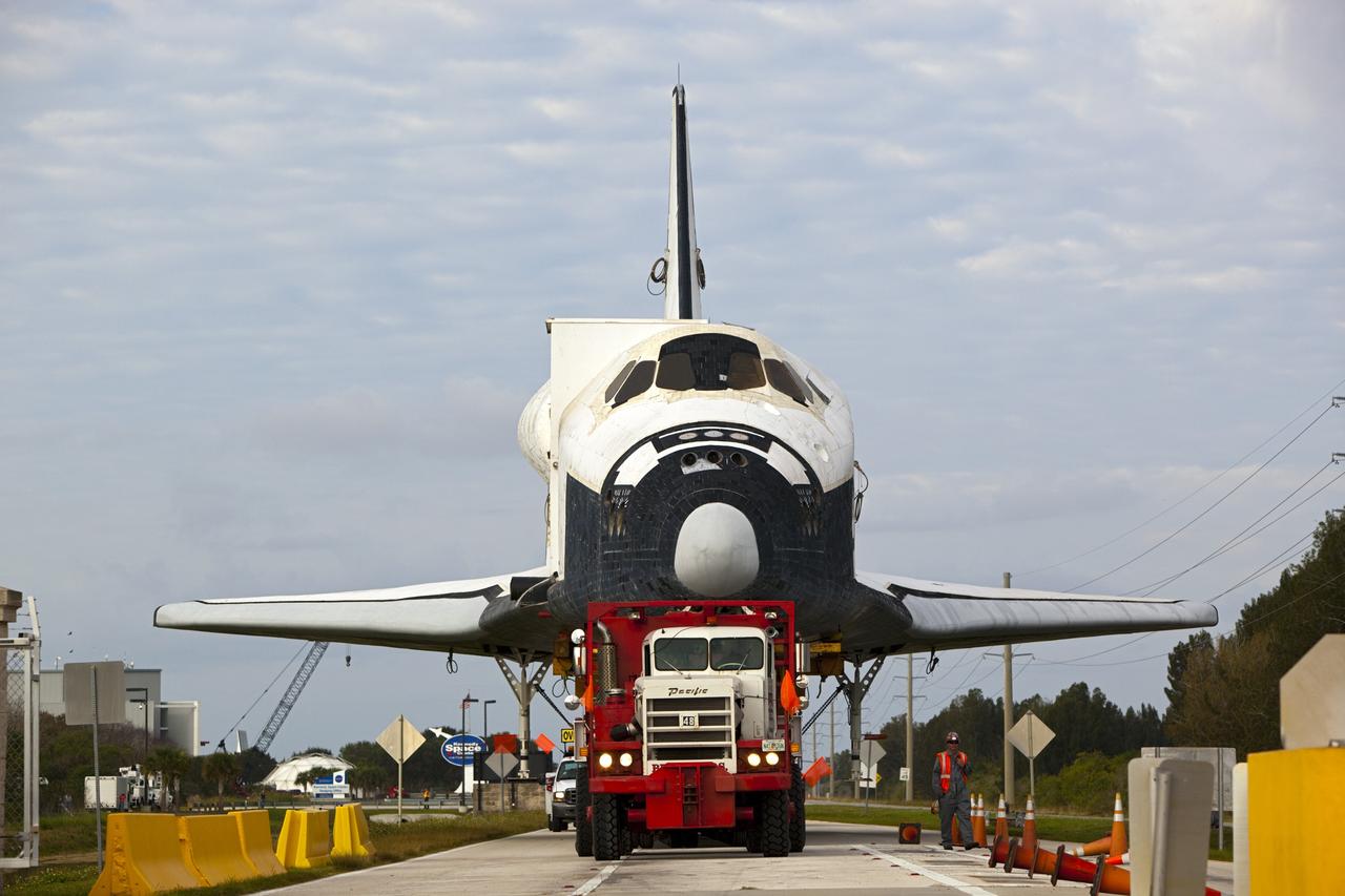 CAPE CANAVERAL, Fla. – The transporter carrying the high-fidelity space shuttle model that was on display at the NASA Kennedy Space Center Visitor Complex in Florida rolls toward one of the security gates at the center.  The model is being moved from the visitor complex to NASA Kennedy Space Center's Launch Complex 39 turn basin.  The shuttle was part of a display at the visitor complex that also included an external tank and two solid rocket boosters that were used to show visitors the size of actual space shuttle components. The full-scale shuttle model is being transferred from Kennedy to Space Center Houston, NASA Johnson Space Center's visitor center. The model will stay at the turn basin for a few months until it is ready to be transported to Texas via barge. The move also helps clear the way for the Kennedy Space Center Visitor Complex to begin construction of a new facility next year to display space shuttle Atlantis in 2013.  For more information about Space Center Houston, visit http://www.spacecenter.org.  Photo credit: NASA/Dimitri Gerondidakis