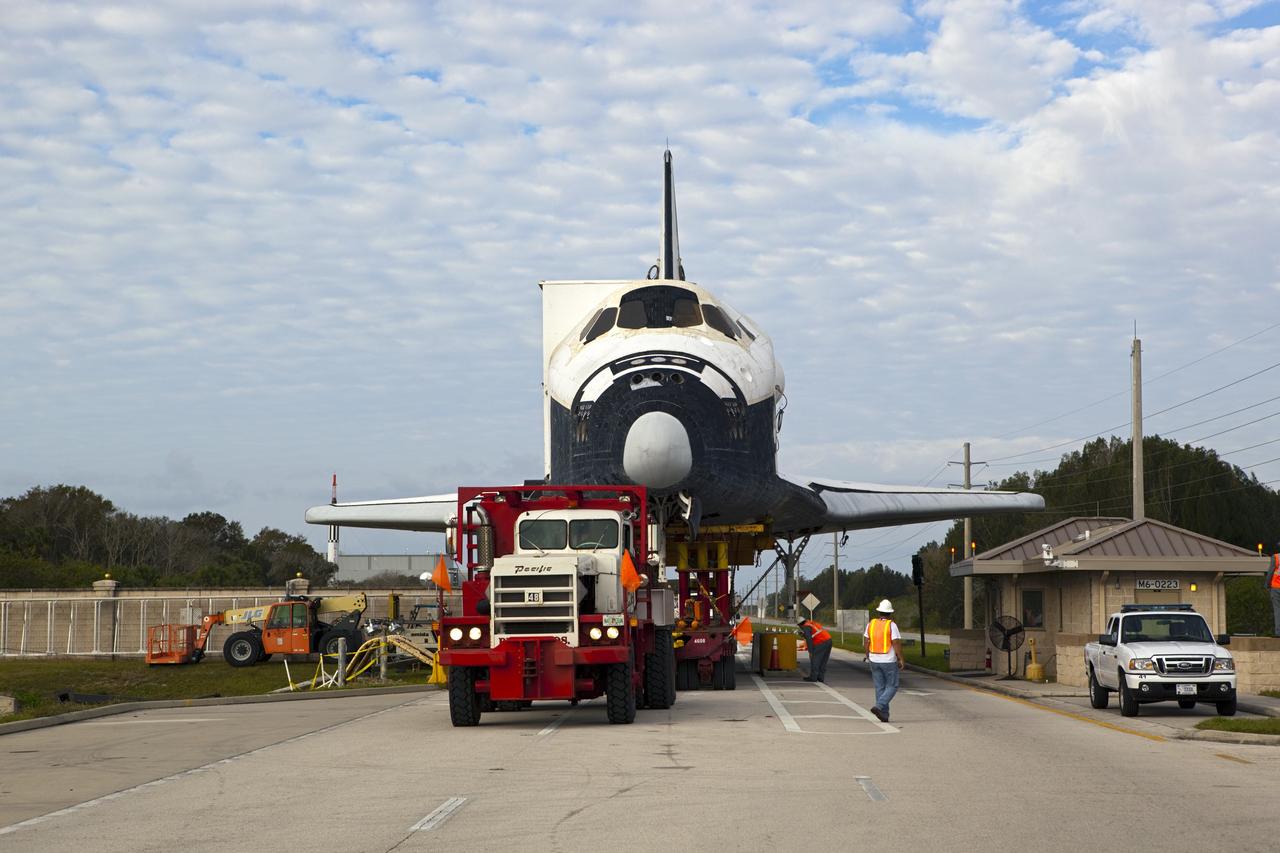 CAPE CANAVERAL, Fla. – A wing of the high-fidelity space shuttle model that was on display at the NASA Kennedy Space Center Visitor Complex in Florida clears the roof of the guard shack at the security gate as it rolls onto the center.  The model is being moved from the visitor complex to NASA Kennedy Space Center's Launch Complex 39 turn basin.  The shuttle was part of a display at the visitor complex that also included an external tank and two solid rocket boosters that were used to show visitors the size of actual space shuttle components. The full-scale shuttle model is being transferred from Kennedy to Space Center Houston, NASA Johnson Space Center's visitor center. The model will stay at the turn basin for a few months until it is ready to be transported to Texas via barge. The move also helps clear the way for the Kennedy Space Center Visitor Complex to begin construction of a new facility next year to display space shuttle Atlantis in 2013.  For more information about Space Center Houston, visit http://www.spacecenter.org.  Photo credit: NASA/Dimitri Gerondidakis