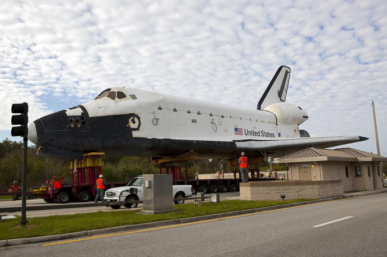 CAPE CANAVERAL, Fla. – A wing of the high-fidelity space shuttle model that was on display at the NASA Kennedy Space Center Visitor Complex in Florida passes over the roof of the guard shack at the security gate as it rolls onto the center.  The model is being moved from the visitor complex to NASA Kennedy Space Center's Launch Complex 39 turn basin.  The shuttle was part of a display at the visitor complex that also included an external tank and two solid rocket boosters that were used to show visitors the size of actual space shuttle components. The full-scale shuttle model is being transferred from Kennedy to Space Center Houston, NASA Johnson Space Center's visitor center. The model will stay at the turn basin for a few months until it is ready to be transported to Texas via barge. The move also helps clear the way for the Kennedy Space Center Visitor Complex to begin construction of a new facility next year to display space shuttle Atlantis in 2013.  For more information about Space Center Houston, visit http://www.spacecenter.org.  Photo credit: NASA/Dimitri Gerondidakis