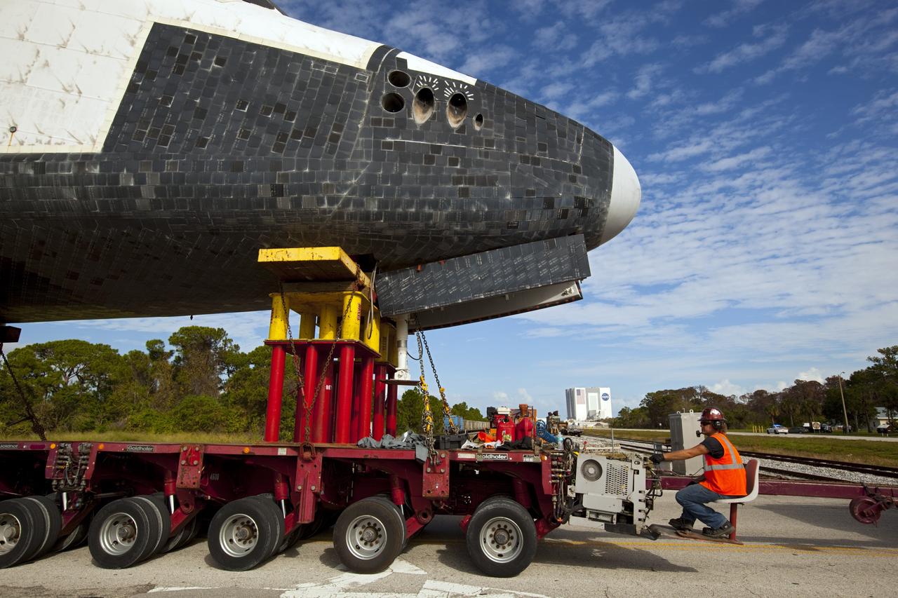 CAPE CANAVERAL, Fla. – The high-fidelity space shuttle model which was on display at the NASA Kennedy Space Center Visitor Complex in Florida makes its way through the center to Kennedy's Launch Complex 39 turn basin.  In the distance is the 525-foot-tall Vehicle Assembly Building.    The shuttle was part of a display at the visitor complex that also included an external tank and two solid rocket boosters that were used to show visitors the size of actual space shuttle components. The full-scale shuttle model is being transferred from Kennedy to Space Center Houston, NASA Johnson Space Center's visitor center. The model will stay at the turn basin for a few months until it is ready to be transported to Texas via barge. The move also helps clear the way for the Kennedy Space Center Visitor Complex to begin construction of a new facility next year to display space shuttle Atlantis in 2013.  For more information about Space Center Houston, visit http://www.spacecenter.org.  Photo credit: NASA/Dimitri Gerondidakis