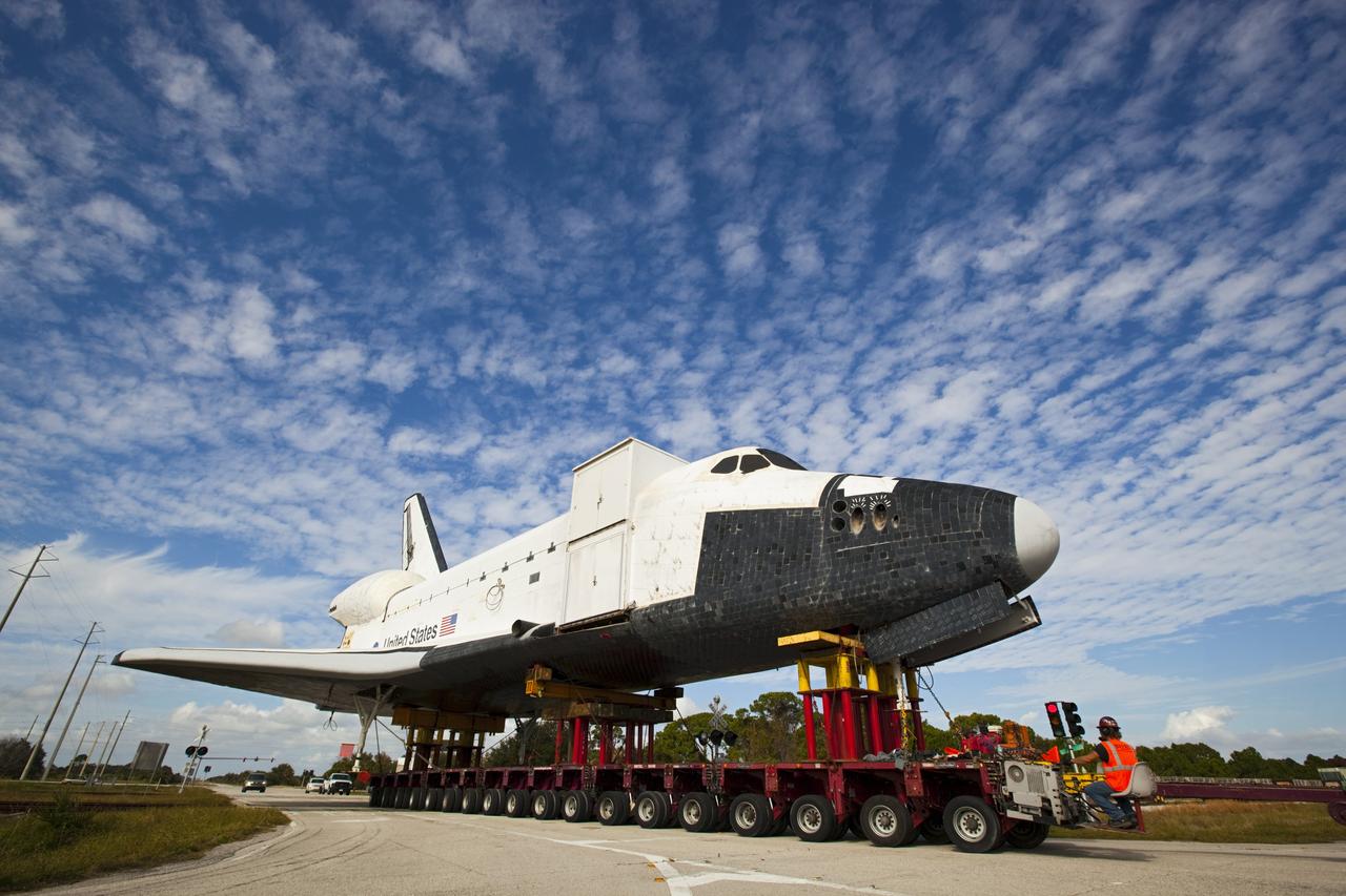 CAPE CANAVERAL, Fla. – The high-fidelity space shuttle model which was on display at the NASA Kennedy Space Center Visitor Complex in Florida makes its way along the center's roadways to Kennedy's Launch Complex 39 turn basin.      The shuttle was part of a display at the visitor complex that also included an external tank and two solid rocket boosters that were used to show visitors the size of actual space shuttle components. The full-scale shuttle model is being transferred from Kennedy to Space Center Houston, NASA Johnson Space Center's visitor center. The model will stay at the turn basin for a few months until it is ready to be transported to Texas via barge. The move also helps clear the way for the Kennedy Space Center Visitor Complex to begin construction of a new facility next year to display space shuttle Atlantis in 2013.  For more information about Space Center Houston, visit http://www.spacecenter.org.  Photo credit: NASA/Dimitri Gerondidakis