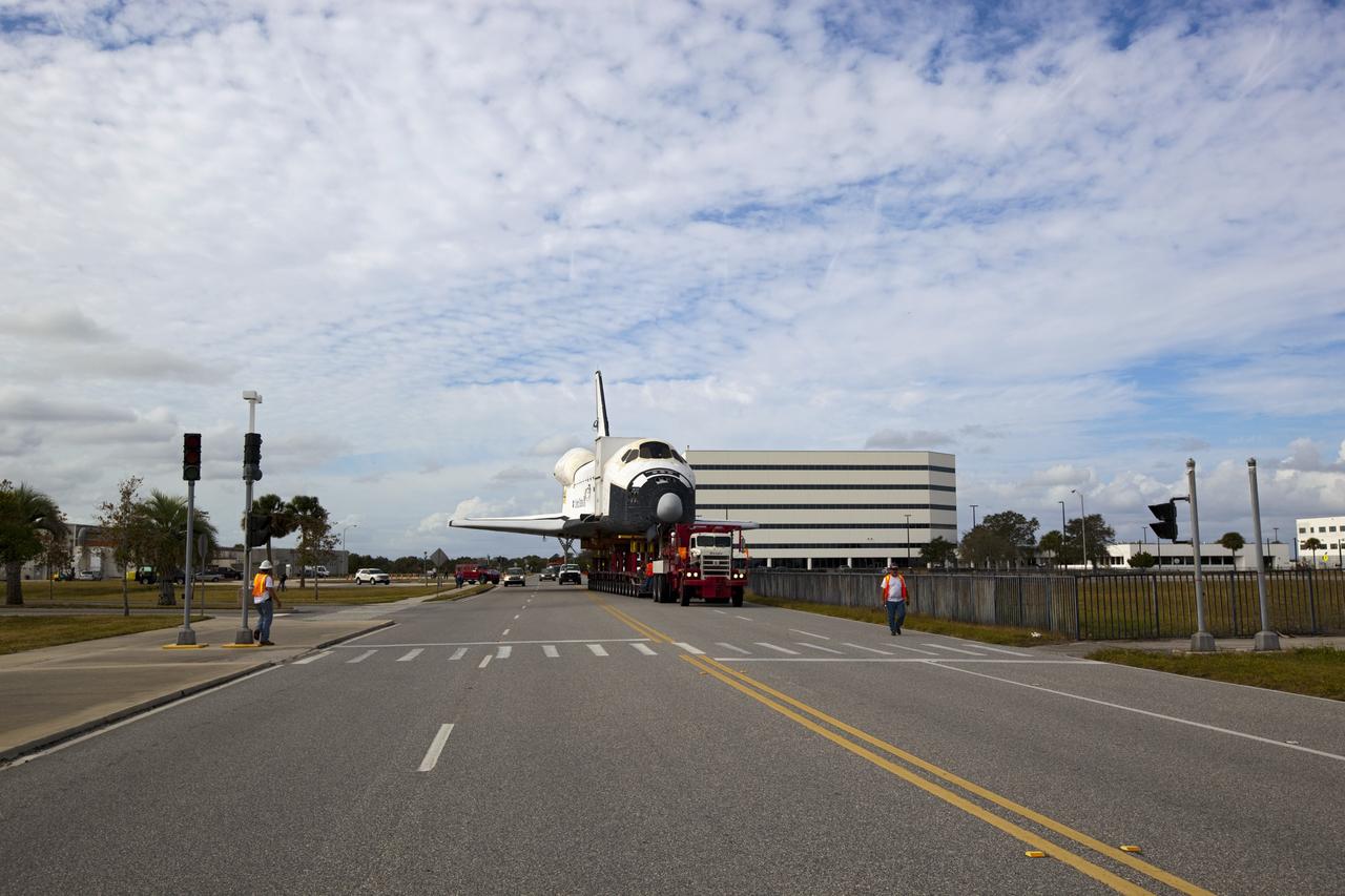 CAPE CANAVERAL, Fla. – The high-fidelity space shuttle model which was on display at the NASA Kennedy Space Center Visitor Complex in Florida travels down Saturn Causeway as it makes its way to Kennedy's Launch Complex 39 turn basin. In the background is the Operations Support Building I.    The shuttle was part of a display at the visitor complex that also included an external tank and two solid rocket boosters that were used to show visitors the size of actual space shuttle components. The full-scale shuttle model is being transferred from Kennedy to Space Center Houston, NASA Johnson Space Center's visitor center. The model will stay at the turn basin for a few months until it is ready to be transported to Texas via barge. The move also helps clear the way for the Kennedy Space Center Visitor Complex to begin construction of a new facility next year to display space shuttle Atlantis in 2013.  For more information about Space Center Houston, visit http://www.spacecenter.org.  Photo credit: NASA/Dimitri Gerondidakis