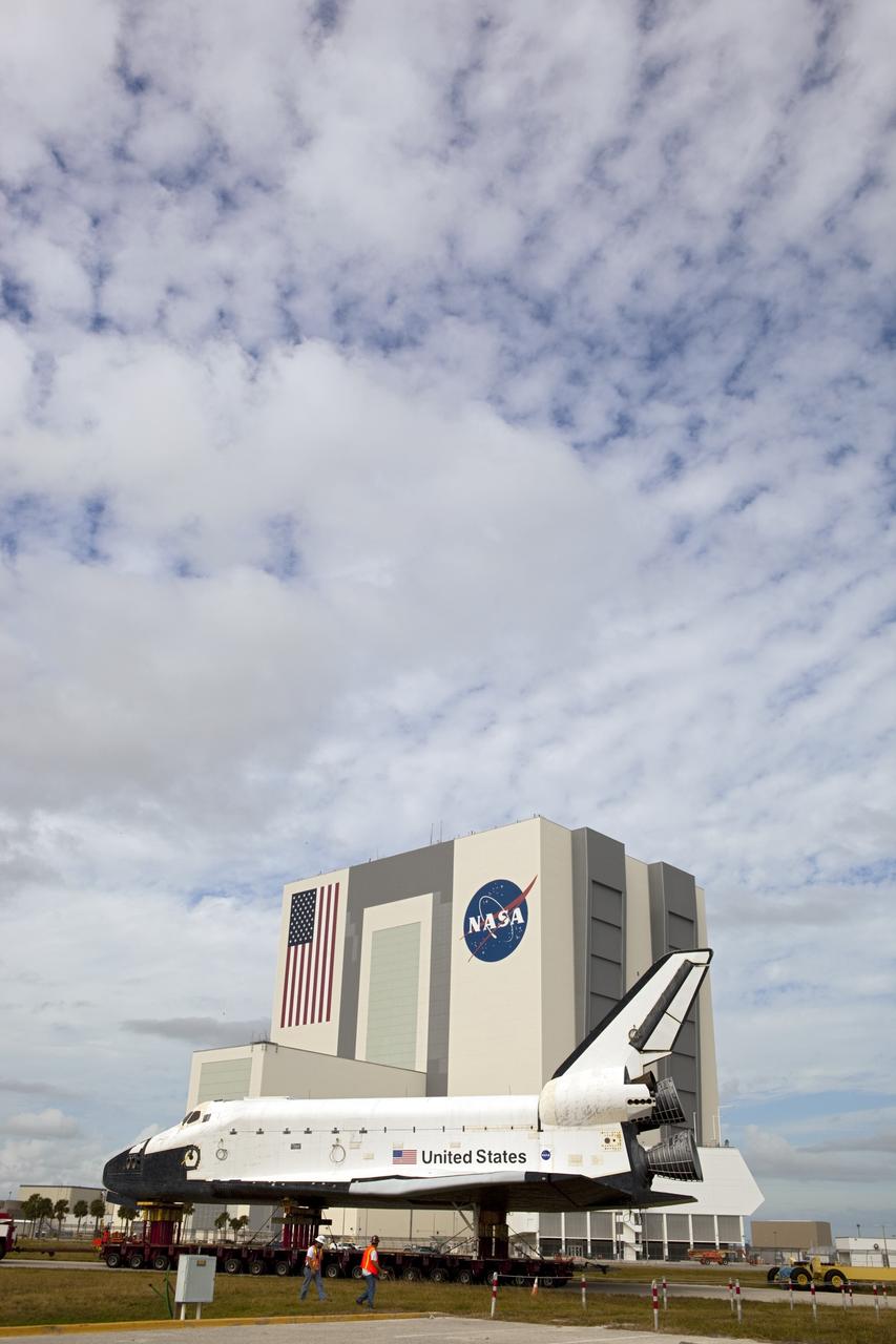 CAPE CANAVERAL, Fla. – The high-fidelity space shuttle model which was on display at the NASA Kennedy Space Center Visitor Complex in Florida backs toward its destination, Kennedy's Launch Complex 39 turn basin.  The Vehicle Assembly Building across the street towers 525 feet above it.     The shuttle was part of a display at the visitor complex that also included an external tank and two solid rocket boosters that were used to show visitors the size of actual space shuttle components. The full-scale shuttle model is being transferred from Kennedy to Space Center Houston, NASA Johnson Space Center's visitor center. The model will stay at the turn basin for a few months until it is ready to be transported to Texas via barge. The move also helps clear the way for the Kennedy Space Center Visitor Complex to begin construction of a new facility next year to display space shuttle Atlantis in 2013.  For more information about Space Center Houston, visit http://www.spacecenter.org.  Photo credit: NASA/Dimitri Gerondidakis