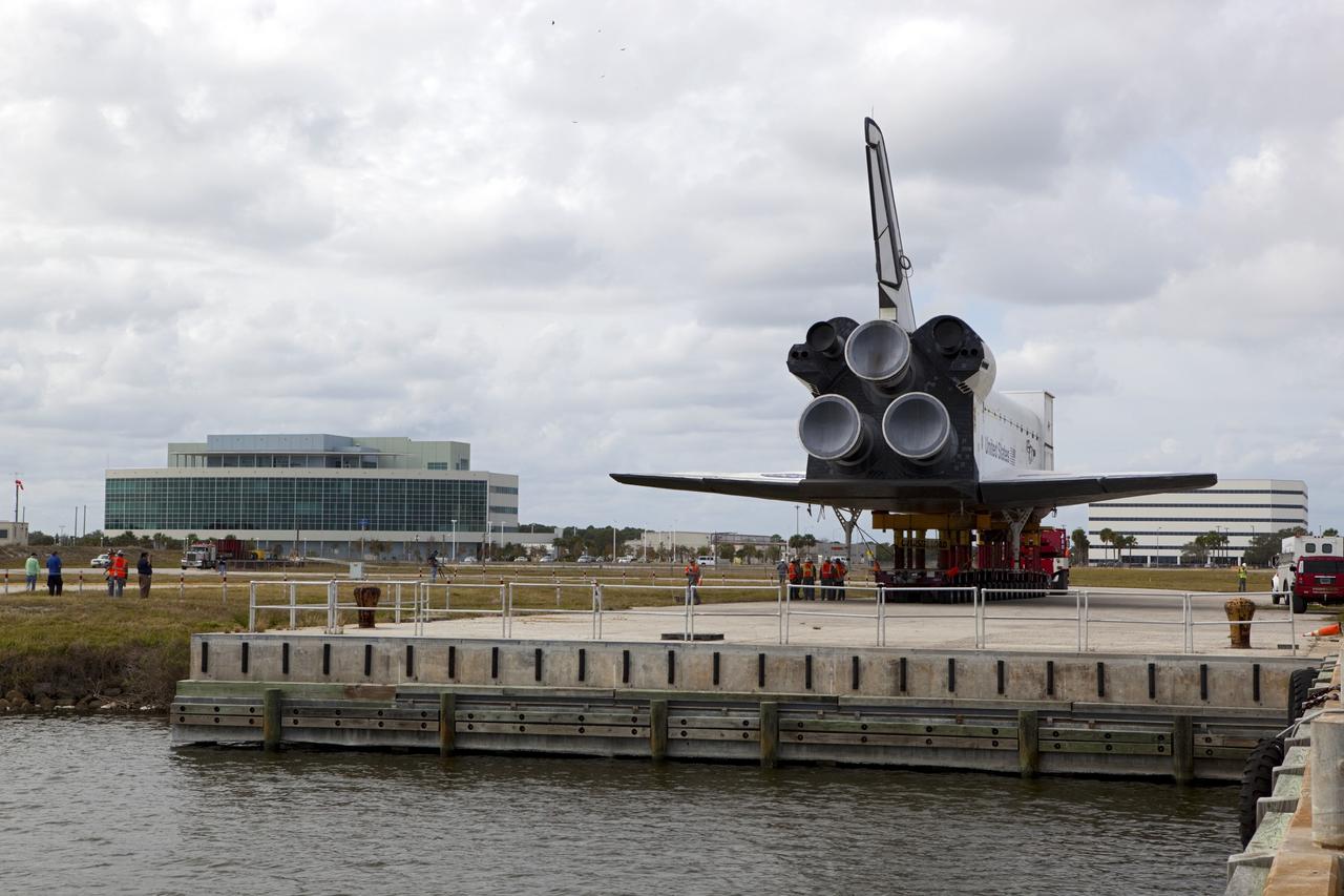 CAPE CANAVERAL, Fla. – The high-fidelity space shuttle model which was on display at the NASA Kennedy Space Center Visitor Complex in Florida rolls to a stop at Kennedy's Launch Complex 39 turn basin.  In the background at left is the Operations Support Building II.     The shuttle was part of a display at the visitor complex that also included an external tank and two solid rocket boosters that were used to show visitors the size of actual space shuttle components. The full-scale shuttle model is being transferred from Kennedy to Space Center Houston, NASA Johnson Space Center's visitor center. The model will stay at the turn basin for a few months until it is ready to be transported to Texas via barge. The move also helps clear the way for the Kennedy Space Center Visitor Complex to begin construction of a new facility next year to display space shuttle Atlantis in 2013.  For more information about Space Center Houston, visit http://www.spacecenter.org.  Photo credit: NASA/Dimitri Gerondidakis