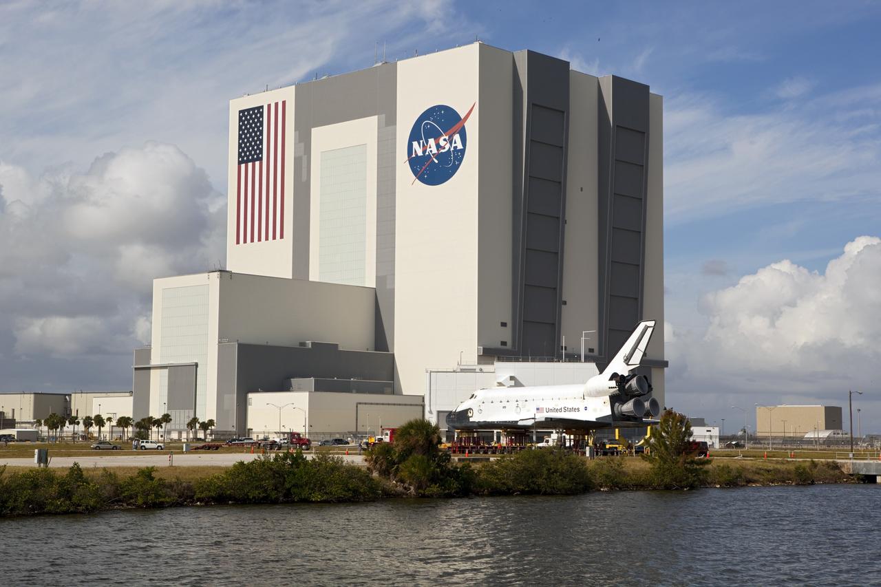 CAPE CANAVERAL, Fla. – The high-fidelity space shuttle model which was on display at the NASA Kennedy Space Center Visitor Complex in Florida seems out of place when viewed across the water of Kennedy's Launch Complex 39 turn basin.  The Vehicle Assembly Building across the street towers 525 feet above it.     The shuttle was part of a display at the visitor complex that also included an external tank and two solid rocket boosters that were used to show visitors the size of actual space shuttle components. The full-scale shuttle model is being transferred from Kennedy to Space Center Houston, NASA Johnson Space Center's visitor center. The model will stay at the turn basin for a few months until it is ready to be transported to Texas via barge. The move also helps clear the way for the Kennedy Space Center Visitor Complex to begin construction of a new facility next year to display space shuttle Atlantis in 2013.  For more information about Space Center Houston, visit http://www.spacecenter.org.  Photo credit: NASA/Dimitri Gerondidakis