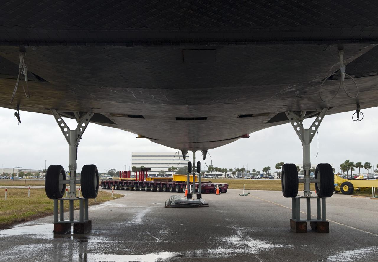 CAPE CANAVERAL, Fla. – Wheels are installed on the high-fidelity space shuttle model following its arrival at Kennedy's Launch Complex 39 turn basin in Florida.  The model was on display at the NASA Kennedy Space Center Visitor Complex until recently. In the distance is the Operations Support Building I.    The shuttle was part of a display at the visitor complex that also included an external tank and two solid rocket boosters that were used to show visitors the size of actual space shuttle components. The full-scale shuttle model is being transferred from Kennedy to Space Center Houston, NASA Johnson Space Center's visitor center. The model will stay at the turn basin for a few months until it is ready to be transported to Texas via barge. The move also helps clear the way for the Kennedy Space Center Visitor Complex to begin construction of a new facility next year to display space shuttle Atlantis in 2013.  For more information about Space Center Houston, visit http://www.spacecenter.org.  Photo credit: NASA/Jim Grossmann