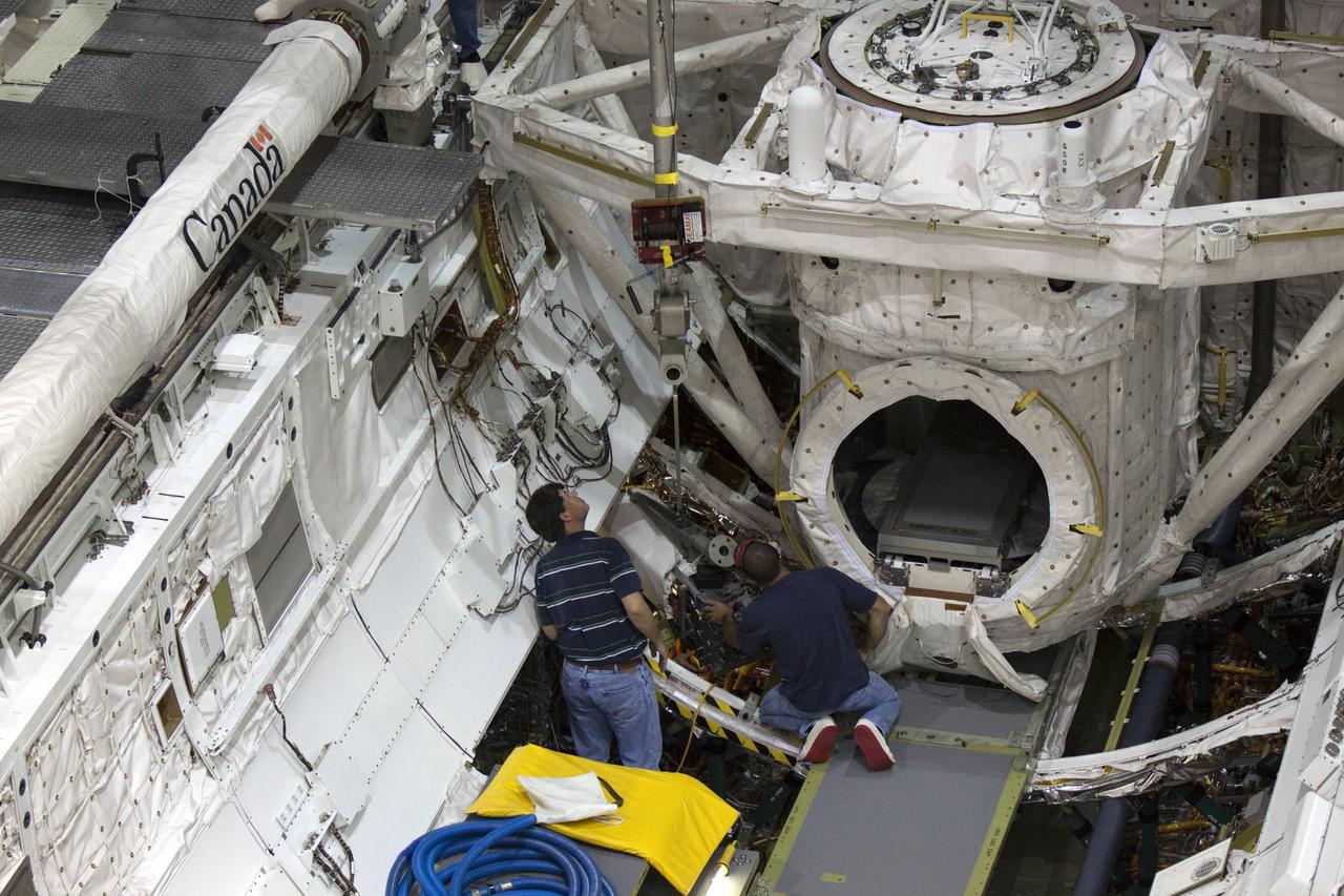 CAPE CANAVERAL, Fla. – Inside Orbiter Processing Facility-2 at NASA’s Kennedy Space Center in Florida, technicians prepare to remove one of three fuel cells from space shuttle Atlantis’ payload bay.    The fuel cells will be drained of all fluids. The hydrogen and oxygen dewars which feed reactants to the fuel cells remain in Atlantis’ mid-body and will be purged with inert gases and vented down. The work is part of the Space Shuttle Program’s transition and retirement processing of shuttle Atlantis. The orbiter is being prepared for display at the Kennedy Space Center Visitor Complex.  Photo credit: NASA/Kim Shiflett