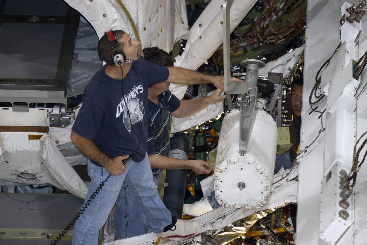 CAPE CANAVERAL, Fla. – Inside Orbiter Processing Facility-2 at NASA’s Kennedy Space Center in Florida, technicians assist as a special crane is used to lift one of the three fuel cells away from space shuttle Atlantis’ payload bay.    The fuel cells will be drained of all fluids. The hydrogen and oxygen dewars which feed reactants to the fuel cells remain in Atlantis’ mid-body and will be purged with inert gases and vented down. The work is part of the Space Shuttle Program’s transition and retirement processing of shuttle Atlantis. The orbiter is being prepared for display at the Kennedy Space Center Visitor Complex.  Photo credit: NASA/Kim Shiflett