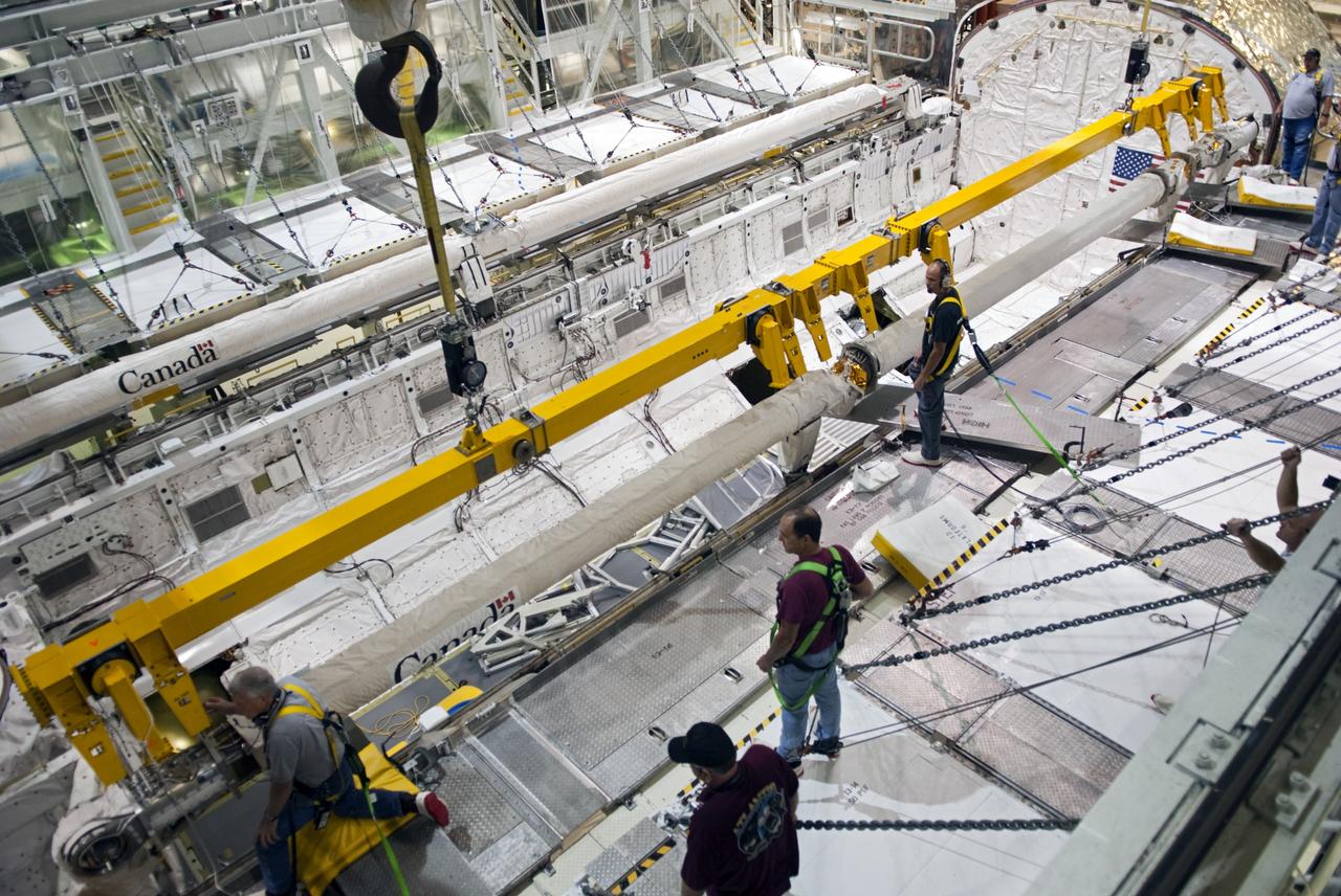 CAPE CANAVERAL, Fla. – Inside Orbiter Processing Facility-2 at NASA’s Kennedy Space Center in Florida, technicians attach a large crane to the remote manipulator system (RMS) robotic arm in space shuttle Atlantis’ payload bay to prepare it for removal.       The RMS will be transported to NASA’s Johnson Space Center in Houston for possible use on future spaceflights. The work is part of the Space Shuttle Program’s transition and retirement processing of shuttle Atlantis. The shuttle is being prepared for display at the Kennedy Space Center Visitor Complex.  Photo credit: NASA/Jim Grossmann