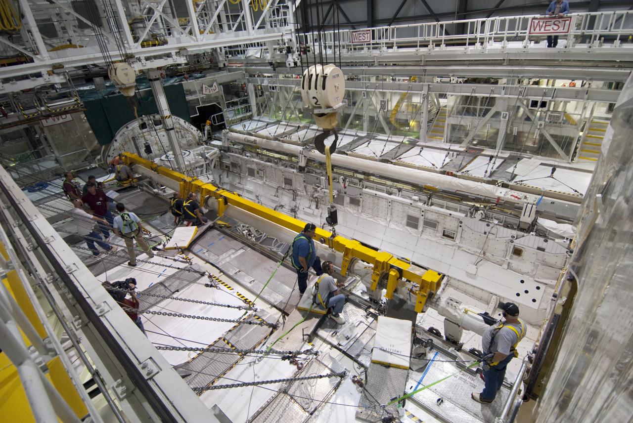 CAPE CANAVERAL, Fla. – Inside Orbiter Processing Facility-2 at NASA’s Kennedy Space Center in Florida, technicians attach a large crane to the remote manipulator system (RMS) robotic arm in space shuttle Atlantis’ payload bay to prepare it for removal.       The RMS will be transported to NASA’s Johnson Space Center in Houston for possible use on future spaceflights. The work is part of the Space Shuttle Program’s transition and retirement processing of shuttle Atlantis. The shuttle is being prepared for display at the Kennedy Space Center Visitor Complex.  Photo credit: NASA/Jim Grossmann