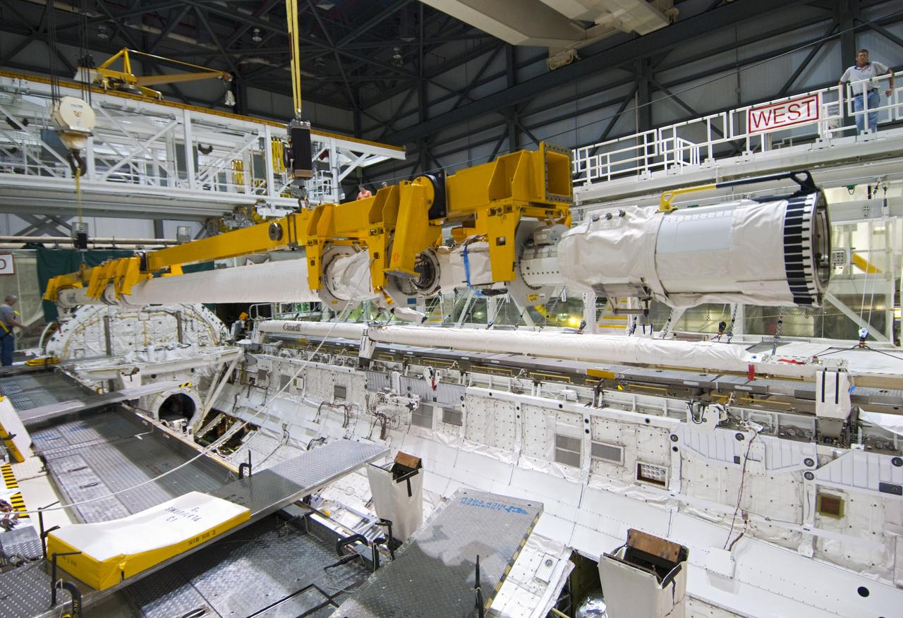 CAPE CANAVERAL, Fla. – Inside Orbiter Processing Facility-2 at NASA’s Kennedy Space Center in Florida, a large crane lifts the remote manipulator system (RMS) robotic arm away from space shuttle Atlantis’ payload bay.      The RMS will be transported to NASA’s Johnson Space Center in Houston for possible use on future spaceflights. The work is part of the Space Shuttle Program’s transition and retirement processing of shuttle Atlantis. The shuttle is being prepared for display at the Kennedy Space Center Visitor Complex.  Photo credit: NASA/Jim Grossmann