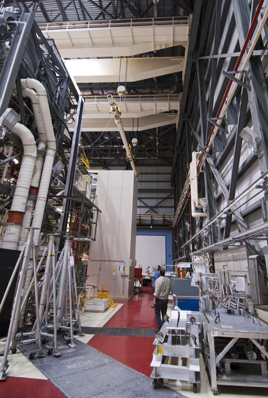CAPE CANAVERAL, Fla. – Inside Orbiter Processing Facility-2 at NASA’s Kennedy Space Center in Florida, technicians monitor the progress as a large crane carries the remote manipulator system (RMS) robotic arm that was removed from space shuttle Atlantis’ payload bay. The RMS will be transported to NASA’s Johnson Space Center in Houston for possible use on future spaceflights. The work is part of the Space Shuttle Program’s transition and retirement processing of shuttle Atlantis. The shuttle is being prepared for display at the Kennedy Space Center Visitor Complex. Photo credit: NASA/Jim Grossmann