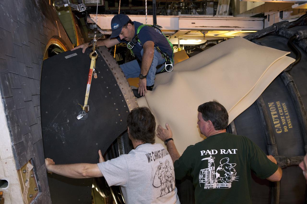 CAPE CANAVERAL, Fla. – Inside Orbiter Processing Facility-1 at NASA’s Kennedy Space Center in Florida, technicians help guide one of space shuttle Discovery’s replica shuttle main engines (RSME) into place after the eyelid and heat shield were installed. The heat shields are composed of two, semi-circle-shaped sections of thermal protection system tiles that surround the engines. The work is part of the Space Shuttle Program’s transition and retirement processing of shuttle Discovery. Discovery is being prepared for display at the Smithsonian’s National Air and Space Museum, Steven F. Udvar-Hazy Center in Chantilly, Va. For more information, visit http://www.nasa.gov/shuttle. Photo credit: NASA/Dimitri Gerondidakis