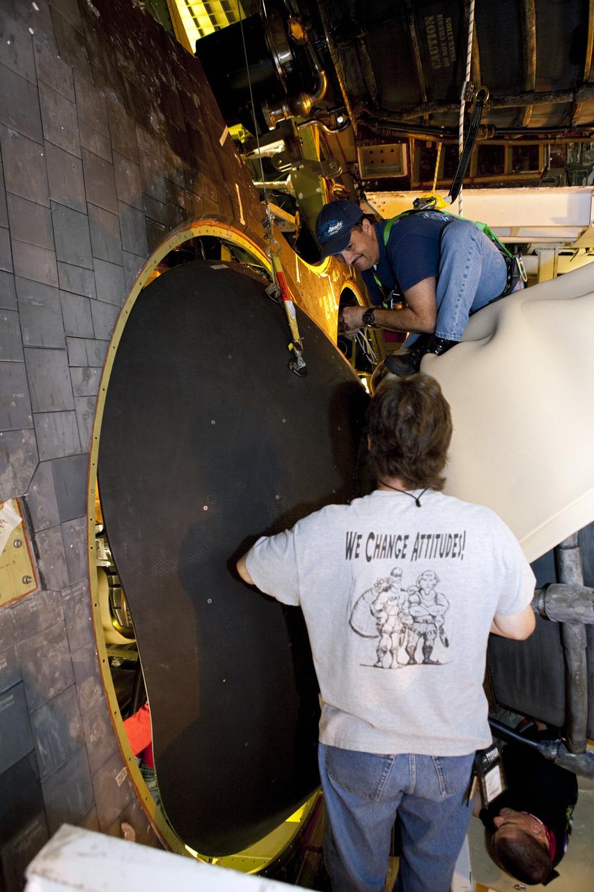 CAPE CANAVERAL, Fla. – Inside Orbiter Processing Facility-1 at NASA’s Kennedy Space Center in Florida, technicians help guide one of space shuttle Discovery’s replica shuttle main engines (RSME) into place after the eyelid and heat shield were installed. The heat shields are composed of two, semi-circle-shaped sections of thermal protection system tiles that surround the engines. The work is part of the Space Shuttle Program’s transition and retirement processing of shuttle Discovery. Discovery is being prepared for display at the Smithsonian’s National Air and Space Museum, Steven F. Udvar-Hazy Center in Chantilly, Va. For more information, visit http://www.nasa.gov/shuttle. Photo credit: NASA/Dimitri Gerondidakis