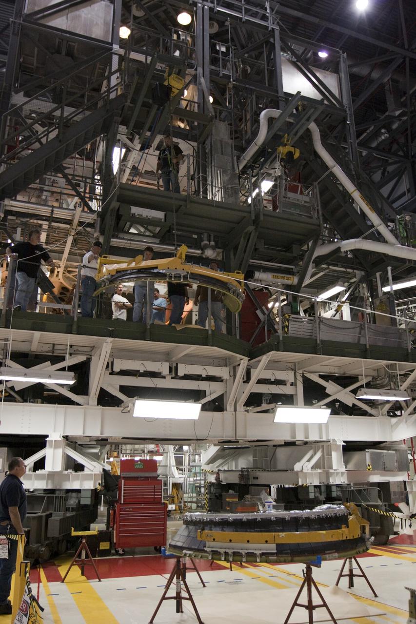 CAPE CANAVERAL, Fla. – Inside Orbiter Processing Facility-1 at NASA’s Kennedy Space Center in Florida, a large crane lifts a dome heat shield that will be installed around one of space shuttle Discovery’s three replica shuttle main engines.     The dome heat shields are composed of two, semi-circle-shaped sections of thermal protection system tiles that surround the engines. The work is part of the Space Shuttle Program’s transition and retirement processing of shuttle Discovery. Discovery is being prepared for display at the Smithsonian’s National Air and Space Museum, Steven F. Udvar-Hazy Center in Chantilly, Va. For more information, visit http://www.nasa.gov/shuttle.  Photo credit: NASA/Kim Shiflett