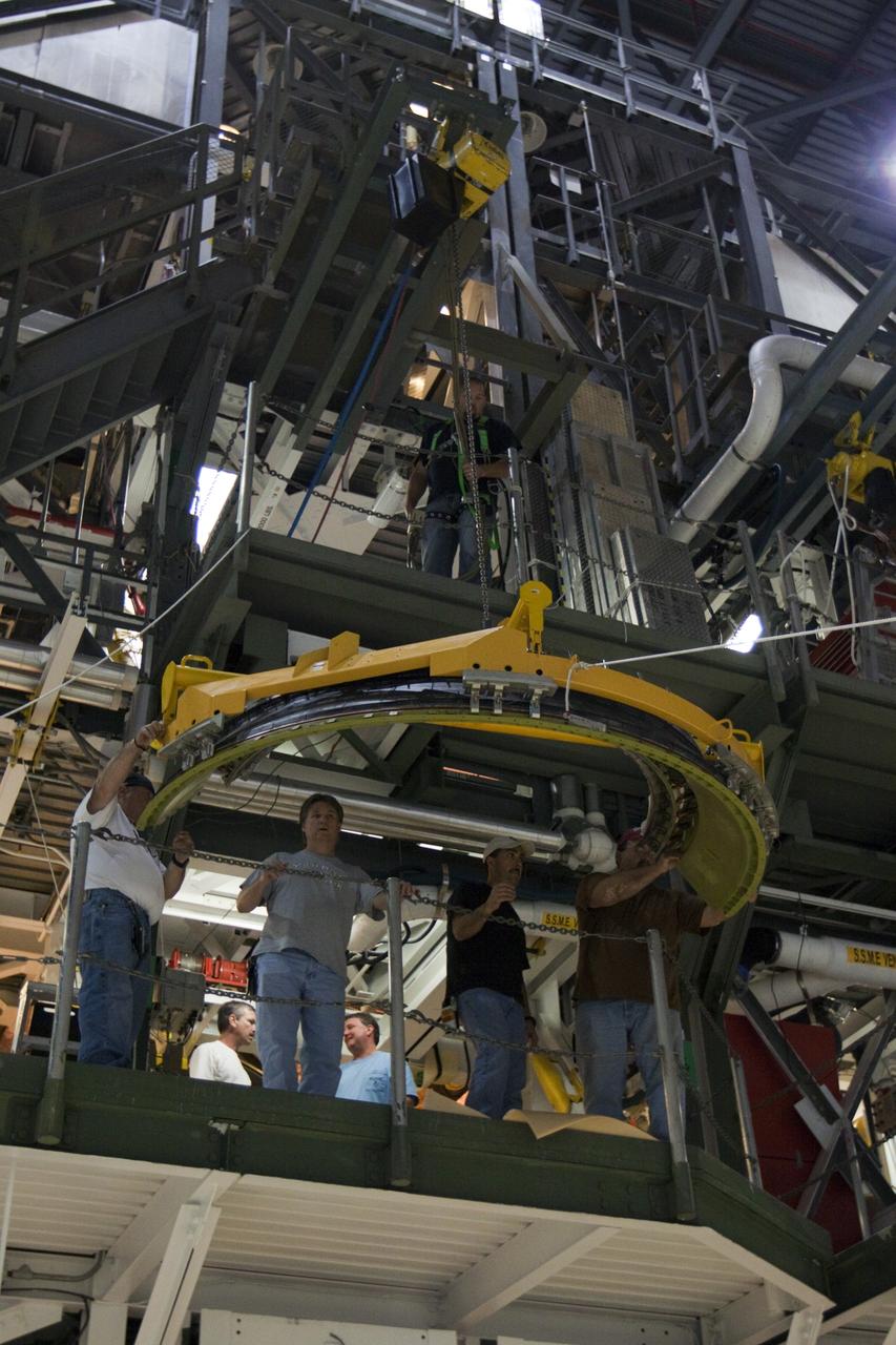 CAPE CANAVERAL, Fla. – Inside Orbiter Processing Facility-1 at NASA’s Kennedy Space Center in Florida, technicians help guide a dome heat shield for installation around one of space shuttle Discovery’s three replica shuttle main engines. The dome heat shields are composed of two, semi-circle-shaped sections of thermal protection system tiles that surround the engines. The work is part of the Space Shuttle Program’s transition and retirement processing of shuttle Discovery. Discovery is being prepared for display at the Smithsonian’s National Air and Space Museum, Steven F. Udvar-Hazy Center in Chantilly, Va. For more information, visit http://www.nasa.gov/shuttle. Photo credit: NASA/Kim Shiflett
