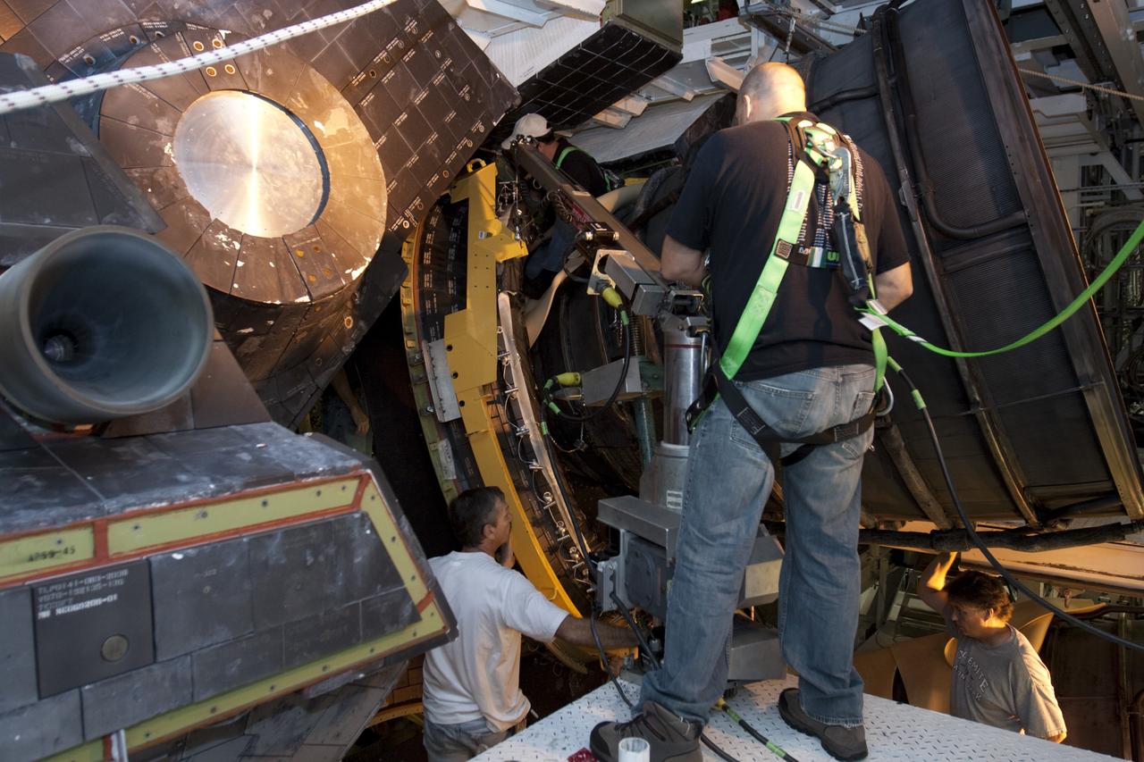CAPE CANAVERAL, Fla. – Inside Orbiter Processing Facility-1 at NASA’s Kennedy Space Center in Florida, technicians install a dome heat shield around one of space shuttle Discovery’s three replica shuttle main engines. The dome heat shields are composed of two, semi-circle-shaped sections of thermal protection system tiles that surround the engines. The work is part of the Space Shuttle Program’s transition and retirement processing of shuttle Discovery. Discovery is being prepared for display at the Smithsonian’s National Air and Space Museum, Steven F. Udvar-Hazy Center in Chantilly, Va. For more information, visit http://www.nasa.gov/shuttle. Photo credit: NASA/Kim Shiflett