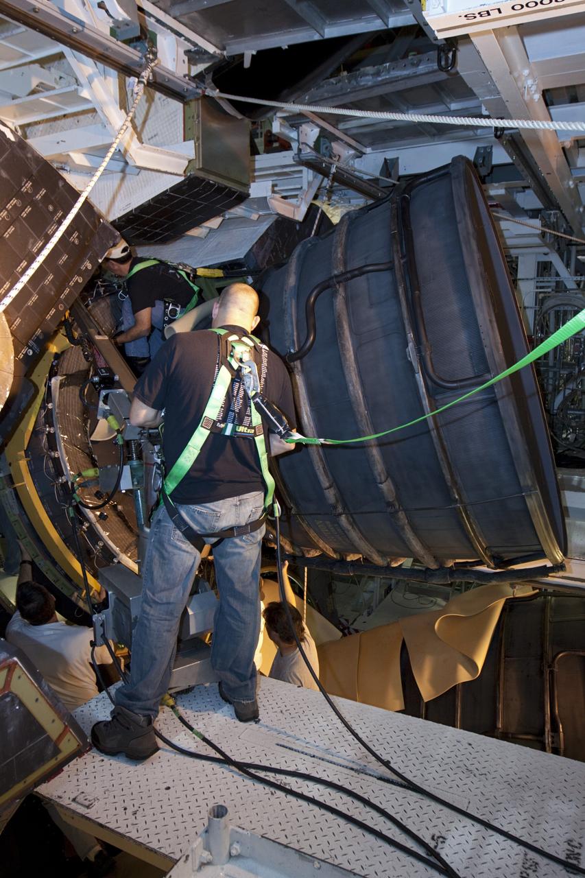 CAPE CANAVERAL, Fla. – Inside Orbiter Processing Facility-1 at NASA’s Kennedy Space Center in Florida, technicians install a dome heat shield around one of space shuttle Discovery’s three replica shuttle main engines. The dome heat shields are composed of two, semi-circle-shaped sections of thermal protection system tiles that surround the engines. The work is part of the Space Shuttle Program’s transition and retirement processing of shuttle Discovery. Discovery is being prepared for display at the Smithsonian’s National Air and Space Museum, Steven F. Udvar-Hazy Center in Chantilly, Va. For more information, visit http://www.nasa.gov/shuttle. Photo credit: NASA/Kim Shiflett
