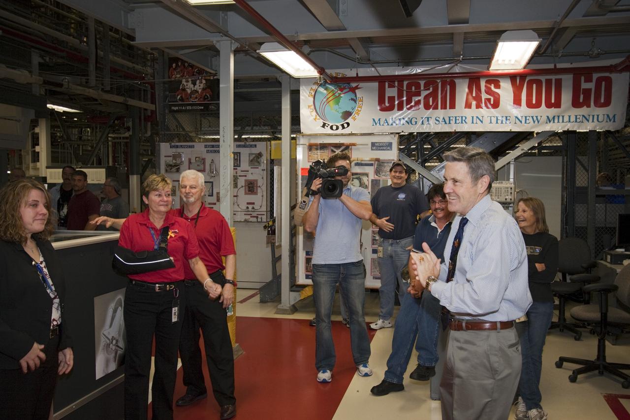 CAPE CANAVERAL, Fla. – In Orbiter Processing Facility-1 at NASA's Kennedy Space Center in Florida, Center Director Robert Cabana, second from right, joins space shuttle support personnel in a ceremony following the final power down of space shuttle Discovery during Space Shuttle Program transition and retirement activities. "Power down" followed the final closure of Discovery's payload bay doors. Discovery is being prepared for public display at the Smithsonian’s National Air and Space Museum Steven F. Udvar-Hazy Center in Chantilly, Va., in 2012. For more information, visit http://www.nasa.gov/shuttle. Photo credit: NASA/Jim Grossmann