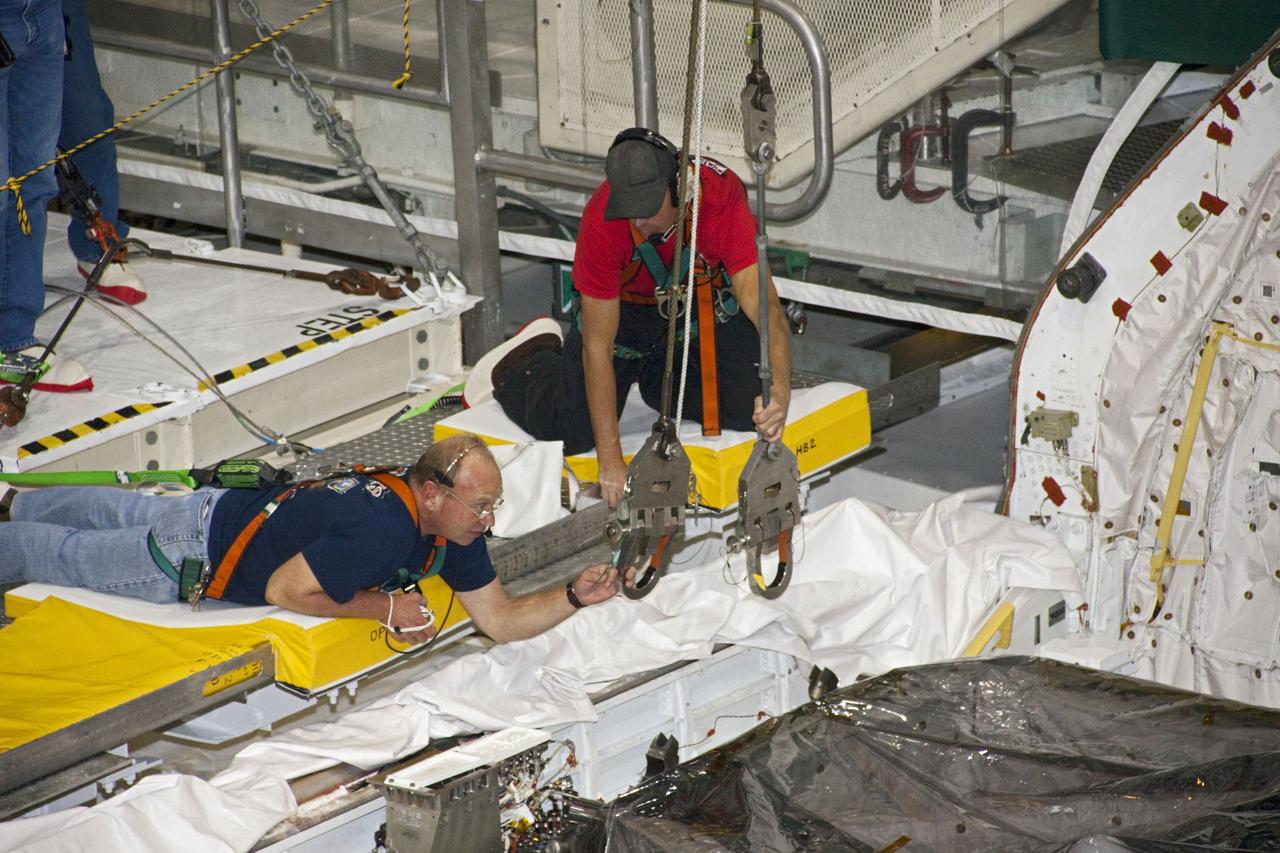CAPE CANAVERAL, Fla. -- Workers prepare to remove the airlock from the cargo bay of space shuttle Atlantis in Orbiter Processing Facility-2 at NASA's Kennedy Space Center in Florida. The airlock was the connecting point between the shuttle and International Space Station. It was removed as part of the ongoing work to prepare the shuttles for public display. The shuttle is being prepared for display at the Kennedy Space Center Visitor Complex. Photo credit: NASA/Jim Grossmann