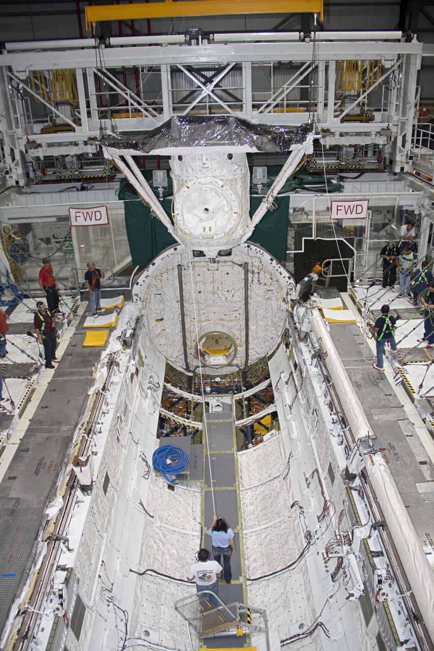 A crane lifts the airlock from the cargo bay of space shuttle Atlantis in Orbiter Processing Facility-2 at NASA's Kennedy Space Center in Florida. The airlock was the connecting point between the shuttle and International Space Station. It was removed as part of the ongoing work to prepare the shuttles for public display. The shuttle is being prepared for display at the Kennedy Space Center Visitor Complex. Photo credit: NASA/Jim Grossmann