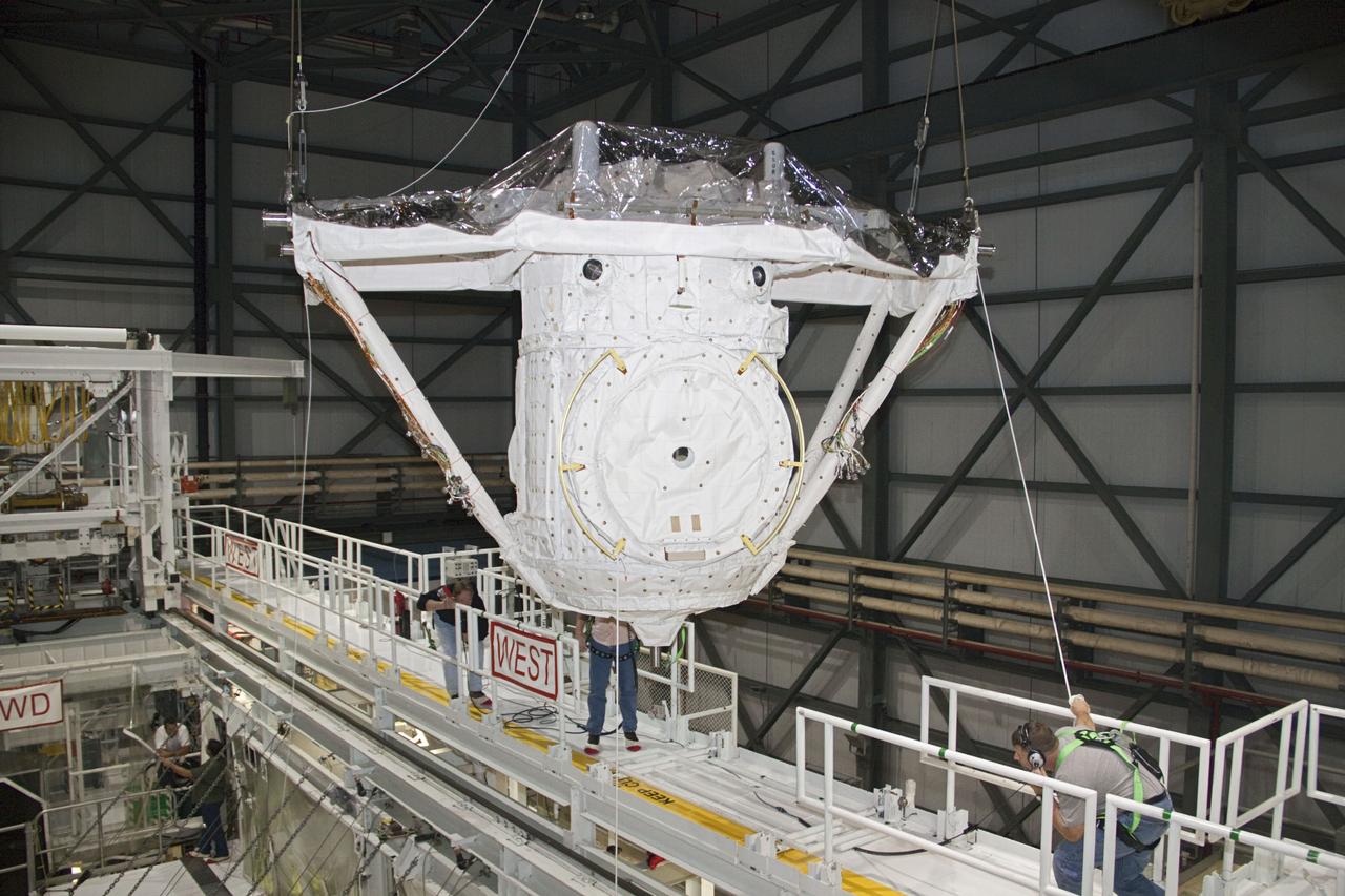 CAPE CANAVERAL, Fla. – A crane lifts the airlock from the cargo bay of space shuttle Atlantis in Orbiter Processing Facility-2 at NASA's Kennedy Space Center in Florida. The airlock was the connecting point between the shuttle and International Space Station. It was removed as part of the ongoing work to prepare the shuttles for public display. The shuttle is being prepared for display at the Kennedy Space Center Visitor Complex. Photo credit: NASA/Jim Grossmann