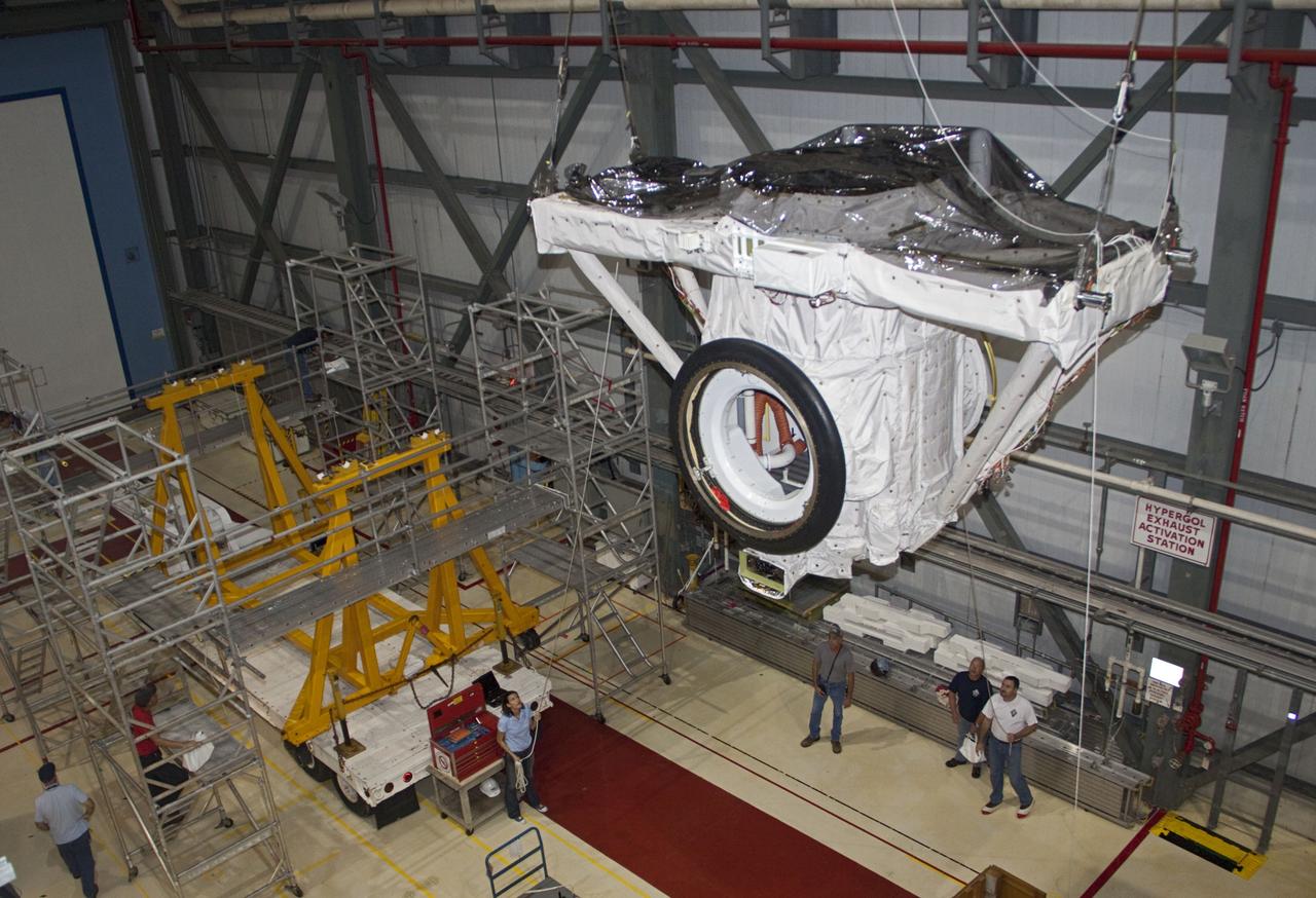CAPE CANAVERAL, Fla. – A crane moves the airlock from the cargo bay of space shuttle Atlantis to a waiting trailer in Orbiter Processing Facility-2 at NASA's Kennedy Space Center in Florida. The airlock was the connecting point between the shuttle and International Space Station. It was removed as part of the ongoing work to prepare the shuttles for public display. The shuttle is being prepared for display at the Kennedy Space Center Visitor Complex. Photo credit: NASA/Jim Grossmann