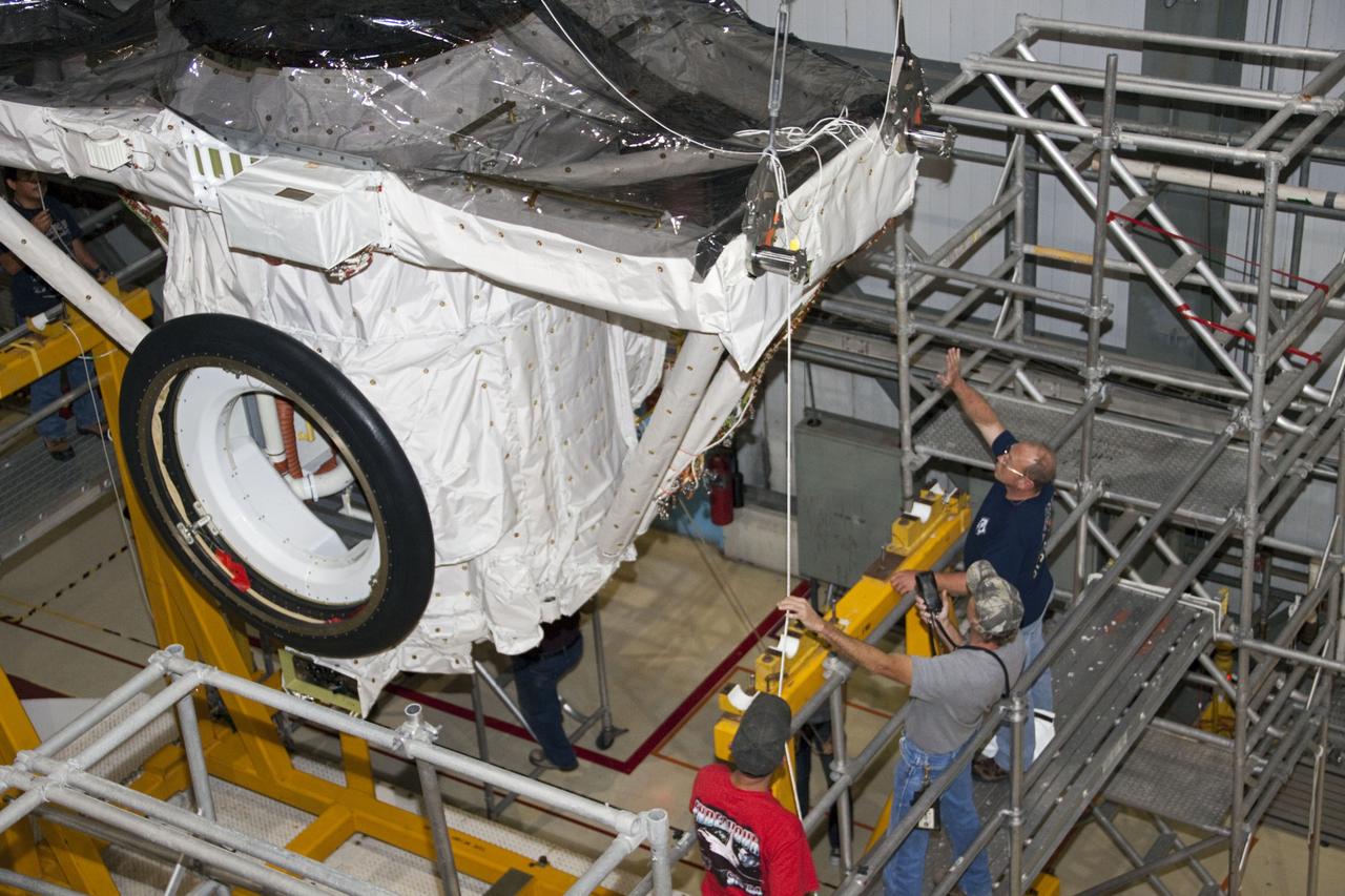 CAPE CANAVERAL, Fla. – A crane moves the airlock from the cargo bay of space shuttle Atlantis to a waiting trailer in Orbiter Processing Facility-2 at NASA's Kennedy Space Center in Florida. The airlock was the connecting point between the shuttle and International Space Station. It was removed as part of the ongoing work to prepare the shuttles for public display. The shuttle is being prepared for display at the Kennedy Space Center Visitor Complex. Photo credit: NASA/Jim Grossmann