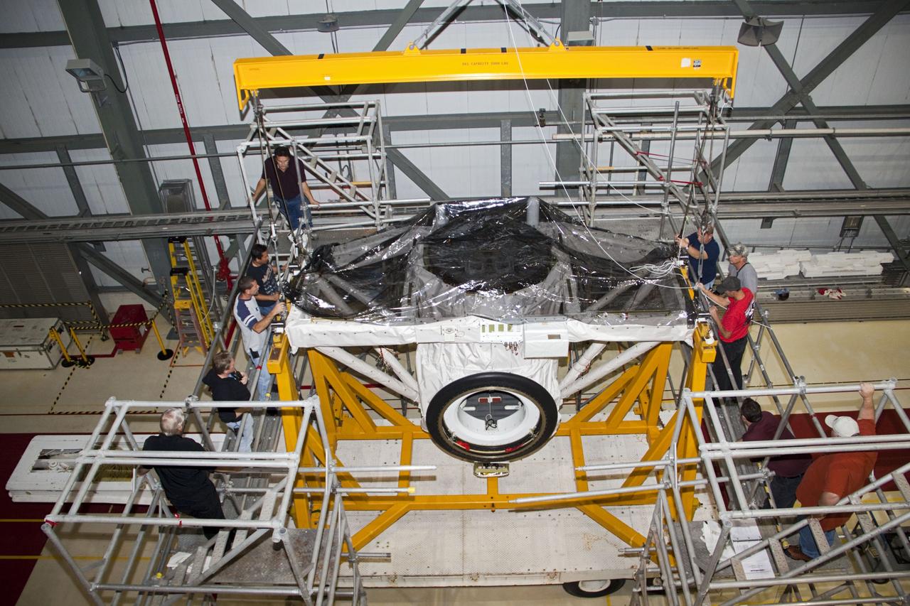 CAPE CANAVERAL, Fla. – A crane moves the airlock from the cargo bay of space shuttle Atlantis to a waiting trailer in Orbiter Processing Facility-2 at NASA's Kennedy Space Center in Florida. The airlock was the connecting point between the shuttle and International Space Station. It was removed as part of the ongoing work to prepare the shuttles for public display. The shuttle is being prepared for display at the Kennedy Space Center Visitor Complex. Photo credit: NASA/Jim Grossmann