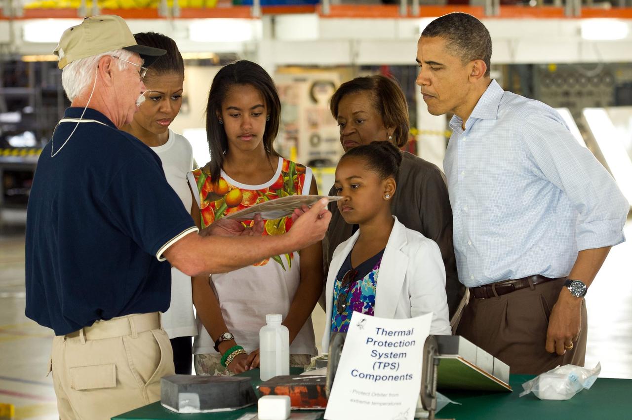 CAPE CANAVERAL, Fla. – (201104290015HQ) Terry White, United Space Alliance project lead for thermal protection systems, left, shows President Barack Obama and his family, from left, First Lady Michelle Obama, Malia, Marian Robinson and Sasha, how tiles work on the space shuttle during their visit to the Orbital Processing Facility at the NASA Kennedy Space Center in Florida.