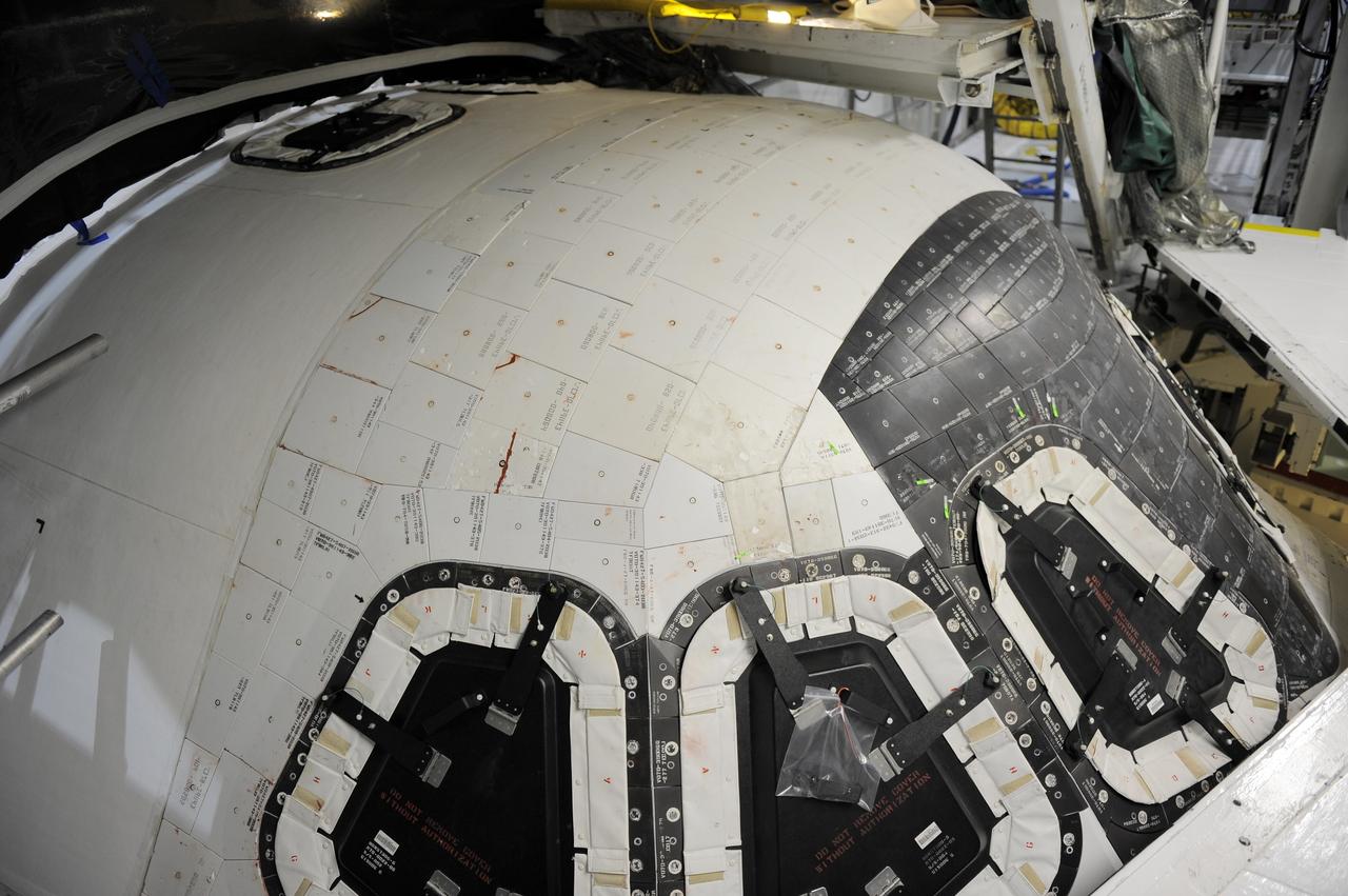 CAPE CANAVERAL, Fla. -- Inside Orbiter Processing Facility-2 at NASA’s Kennedy Space Center in Florida, space shuttle Atlantis is being prepared for removal of the top emergency escape window.     The window is being removed in order to gain access to remove hazardous pyrotechnics from the shuttle. The window will be shipped to Johnson Space Center in Houston for inspections and a replacement outer pane will be installed in its place. The work is part of the Space Shuttle Program’s transition and retirement processing of shuttle Atlantis. The shuttle is being prepared for display at the Kennedy Space Center Visitor Complex in Florida.  Photo credit: NASA/Kim Shiflett