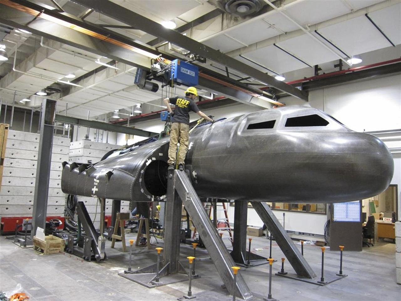BOULDER, Colo. – A Sierra Nevada Corp. team member examines the company's structural test article for the Dream Chaser spacecraft in the University of Colorado at Boulder’s Facility for Advanced Spatial Technology. The university is one of Sierra Nevada’s partners on the design and development of the Dream Chaser orbital crew vehicle. Dream Chaser is one of five systems NASA invested in during Commercial Crew Development Round 1 CCDev1 activities in order to aid in the innovation and development of American-led commercial capabilities for crew transportation and rescue services to and from the International Space Station and other low Earth orbit destinations. In 2011, NASA's Commercial Crew Program CCP entered into another funded Space Act Agreement with Sierra Nevada for the second round of commercial crew development CCDev2) so the company could further develop its Dream Chaser spacecraft for NASA transportation services. For information about CCP, visit www.nasa.gov/commercialcrew. Photo credit: Sierra Nevada Corp.
