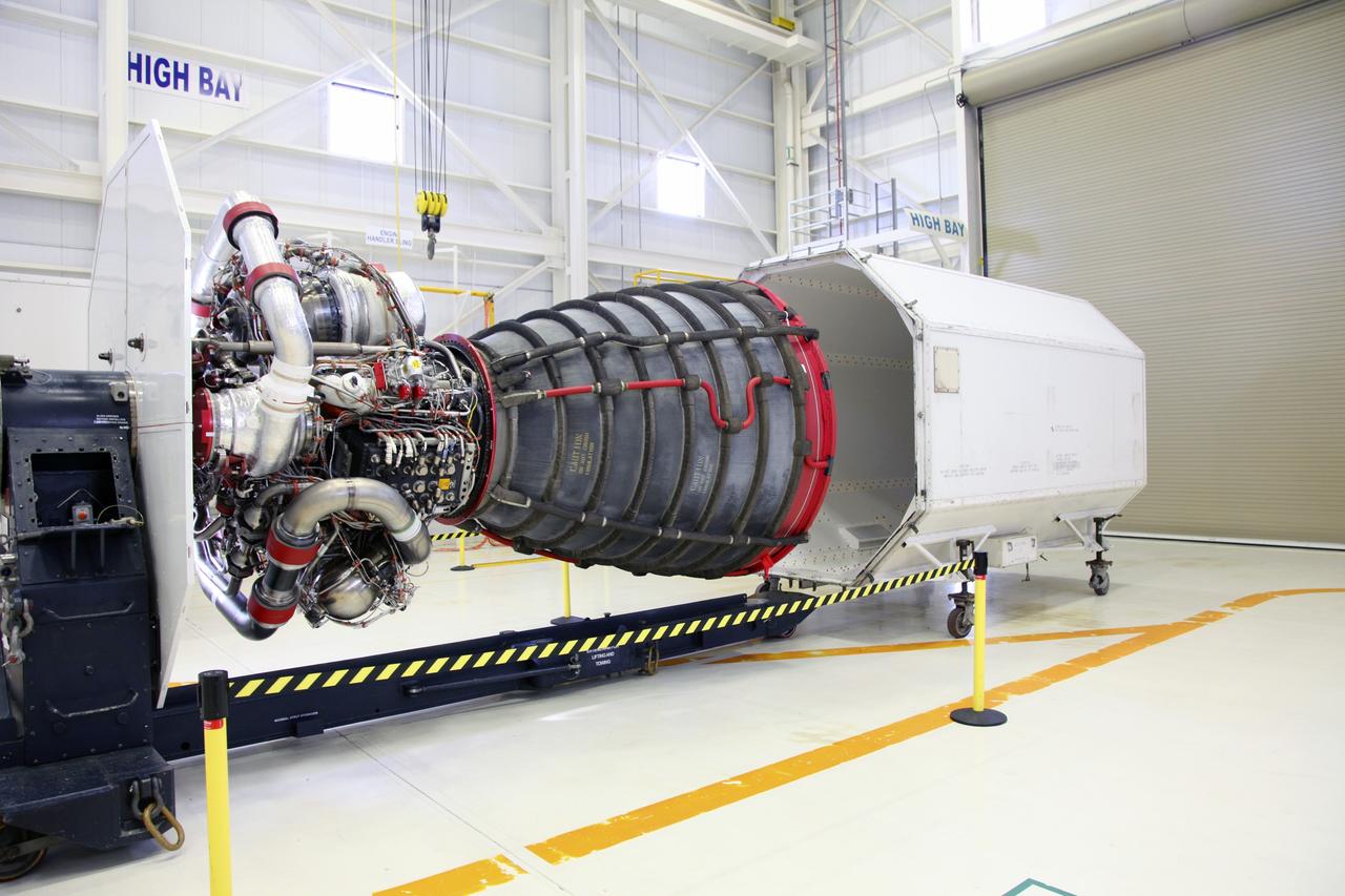 CAPE CANAVERAL, Fla. – In the Space Shuttle Main Engine Processing Facility at NASA’s Kennedy Space Center in Florida, a transportation canister rolls toward a Pratt Whitney Rocketdyne space shuttle main engine (SSME).    This is the second of the 15 engines used during the Space Shuttle Program to be prepared for transfer to NASA's Stennis Space Center in Mississippi. The engines will be stored at Stennis for future use on NASA's new heavy-lift rocket, the Space Launch System (SLS), which will carry NASA's new Orion spacecraft, cargo, equipment and science experiments to space.  For more information, visit http://www.nasa.gov/shuttle.  Photo credit: NASA/Gianni Woods