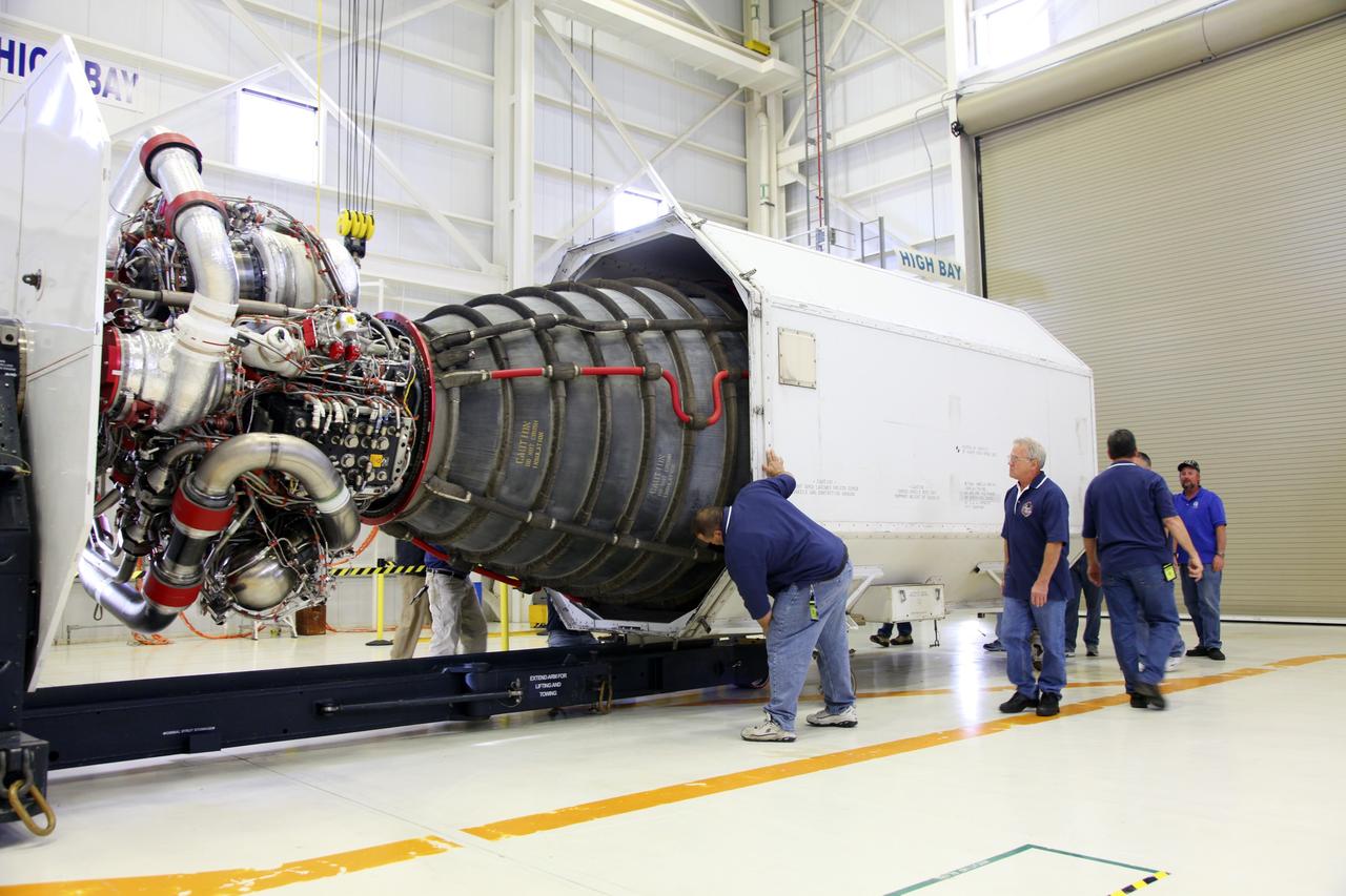 CAPE CANAVERAL, Fla. – In the Space Shuttle Main Engine Processing Facility at NASA’s Kennedy Space Center in Florida, technicians guide a transportation canister as it encloses a Pratt Whitney Rocketdyne space shuttle main engine (SSME).    This is the second of the 15 engines used during the Space Shuttle Program to be prepared for transfer to NASA's Stennis Space Center in Mississippi. The engines will be stored at Stennis for future use on NASA's new heavy-lift rocket, the Space Launch System (SLS), which will carry NASA's new Orion spacecraft, cargo, equipment and science experiments to space.  For more information, visit http://www.nasa.gov/shuttle.  Photo credit: NASA/Gianni Woods