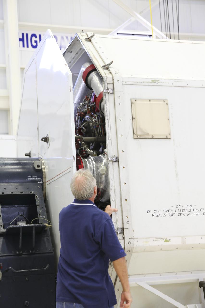 CAPE CANAVERAL, Fla. – In the Space Shuttle Main Engine Processing Facility at NASA’s Kennedy Space Center in Florida, a technician oversees the closure of a transportation canister containing a Pratt Whitney Rocketdyne space shuttle main engine (SSME). This is the second of the 15 engines used during the Space Shuttle Program to be prepared for transfer to NASA's Stennis Space Center in Mississippi. The engines will be stored at Stennis for future use on NASA's new heavy-lift rocket, the Space Launch System (SLS), which will carry NASA's new Orion spacecraft, cargo, equipment and science experiments to space. For more information, visit http://www.nasa.gov/shuttle. Photo credit: NASA/Gianni Woods