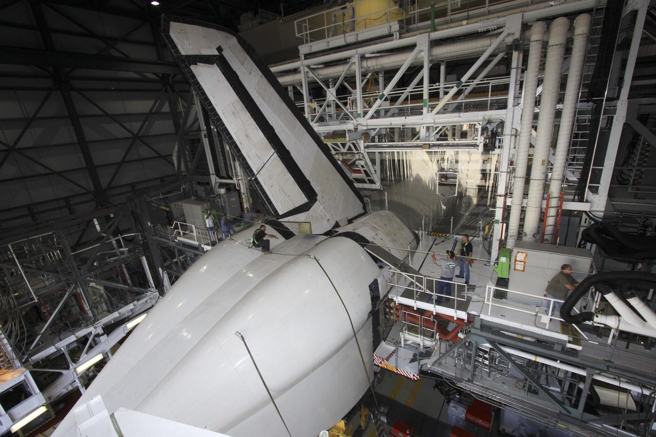 CAPE CANAVERAL, Fla. -- Inside Orbiter Processing Facility-1 at NASA’s Kennedy Space Center in Florida, technicians help secure the tail cone around space shuttle Discovery’s three replica shuttle main engines for protection.    The work is part of the Space Shuttle Program’s transition and retirement processing of shuttle Discovery. Discovery is being prepared for display at the Smithsonian’s National Air and Space Museum, Steven F. Udvar-Hazy Center in Chantilly, Va. For more information, visit http://www.nasa.gov/shuttle.  Photo credit: NASA/Jim Grossmann