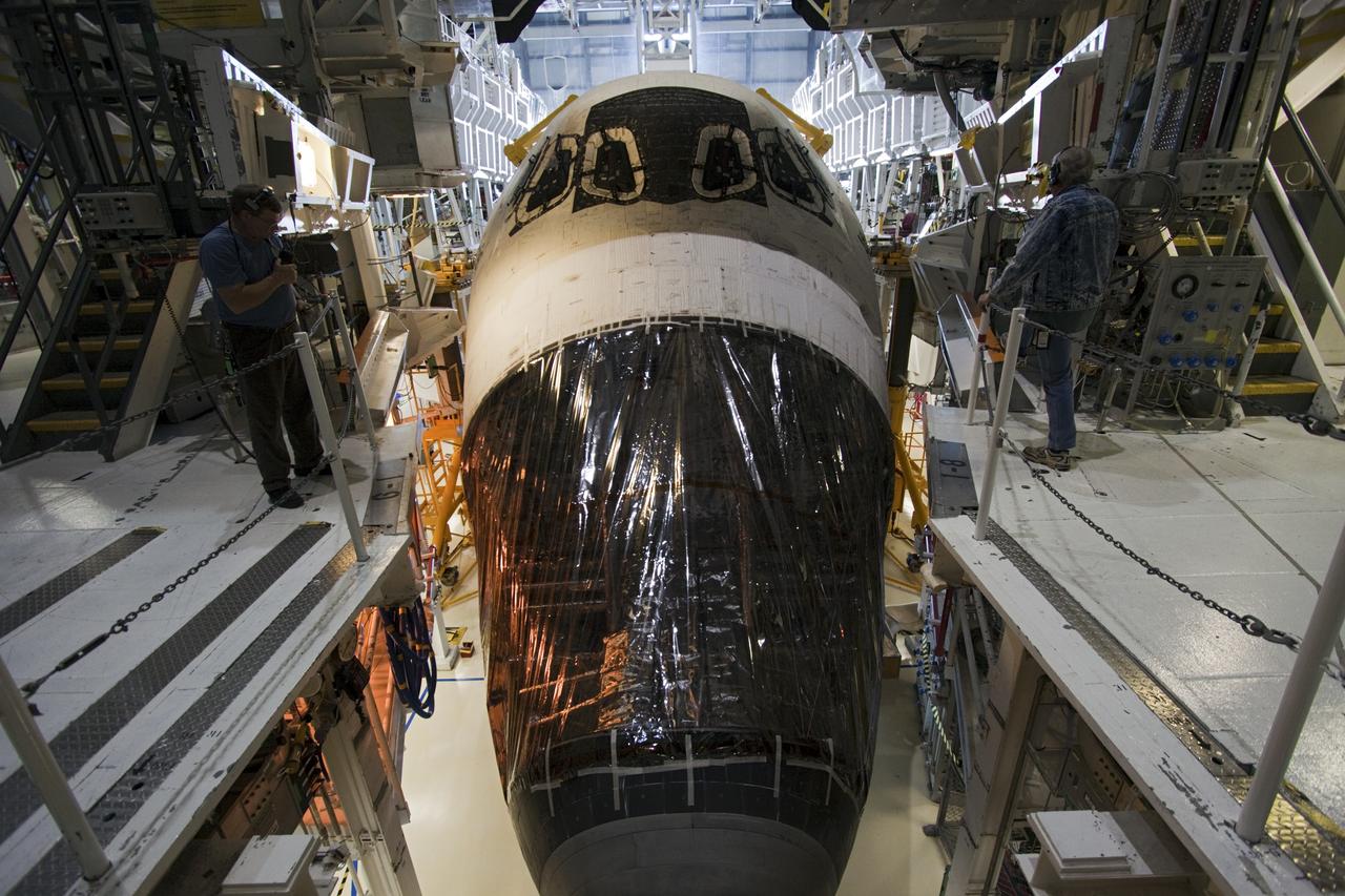 CAPE CANAVERAL, Fla. -- A worker acts as spotter for space shuttle Atlantis as it is backed out from under the work platforms in Orbiter Processing Facility-2 on its move to the Vehicle Assembly Building (VAB) at NASA's Kennedy Space Center in Florida. Atlantis will be stored temporarily in the VAB while transition and retirement processing resumes on shuttle Endeavour in the processing hangar. Endeavour is being prepared for public display at the California Science Center in Los Angeles. A groundbreaking was held Jan. 18 for Atlantis' future home -- a 65,000-square-foot exhibit in Shuttle Plaza at the Kennedy Space Center Visitor Complex. For additional information, visit http://www.nasa.gov/shuttle. Photo credit: NASA/Jim Grossmann
