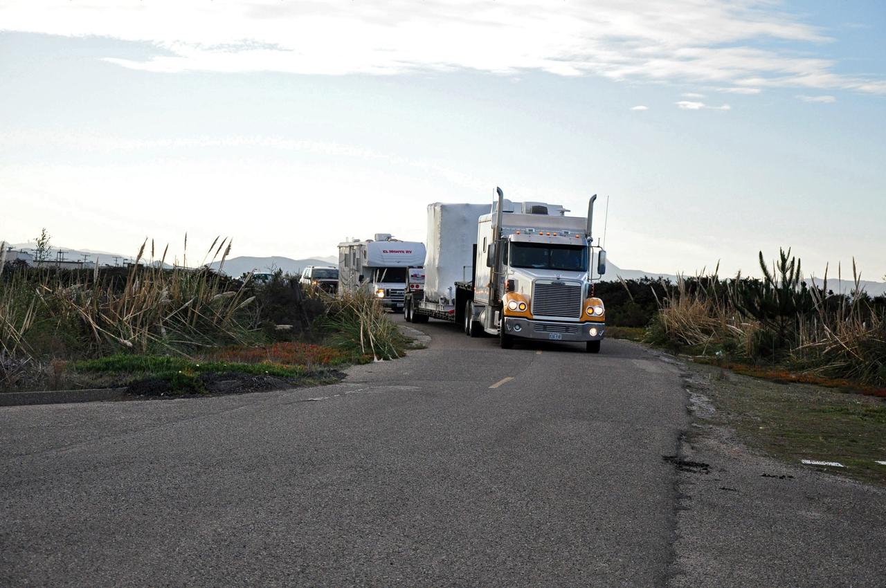 VANDENBERG AIR FORCE BASE, Calif. -- NASA's Nuclear Spectroscopic Telescope Array (NuSTAR), enclosed in an environmentally controlled shipping container, is delivered by tractor-trailer to processing facility 1555 at Vandenberg Air Force Base (VAFB) in California. The spacecraft arrived at 7:52 a.m. PST after a cross-country trip from Orbital Sciences' manufacturing plant in Dulles, Va., which began Jan. 24. The spacecraft will be offloaded into the processing hangar, joining the Pegasus XL rocket that is set to carry it to space. After NuSTAR is removed from its shipping container, checkout and other processing activity will begin. The spacecraft will be integrated with the Pegasus in mid-February and encapsulation in the vehicle fairing will follow. After processing is completed, the rocket and spacecraft will be flown on Orbital's L-1011 carrier aircraft to the Ronald Reagan Ballistic Missile Defense Test Site at the Pacific Ocean's Kwajalein Atoll for launch in March. The high-energy x-ray telescope will conduct a census for black holes, map radioactive material in young supernovae remnants, and study the origins of cosmic rays and the extreme physics around collapsed stars. For more information, visit http://www.nasa.gov/nustar. Photo credit: NASA/Randy Beaudoin, VAFB